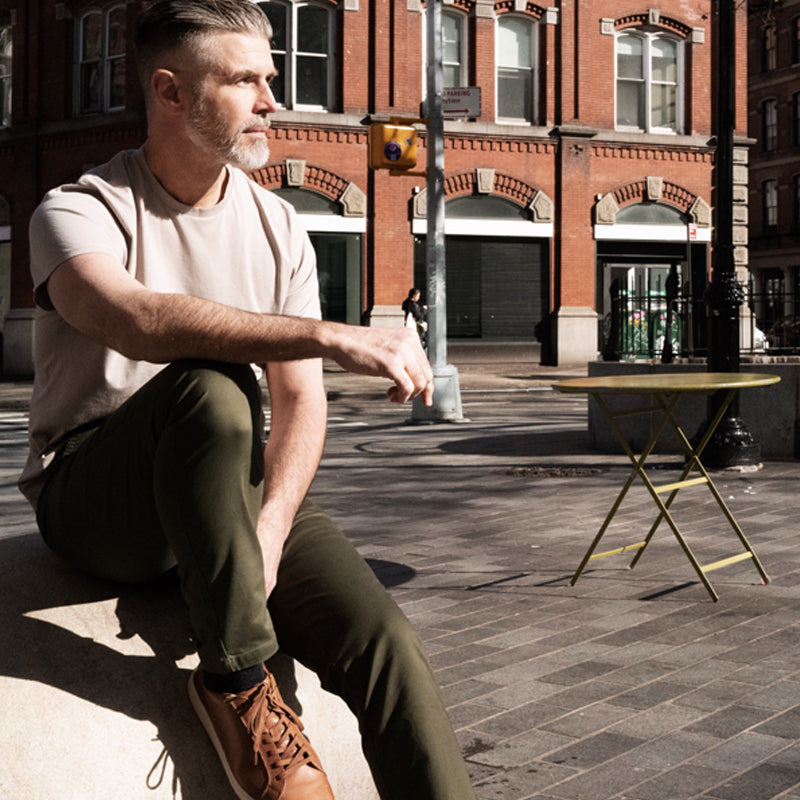 A pair of olive camo chinos designed for active men, showcasing a slim tapered fit and comfortable fabric.