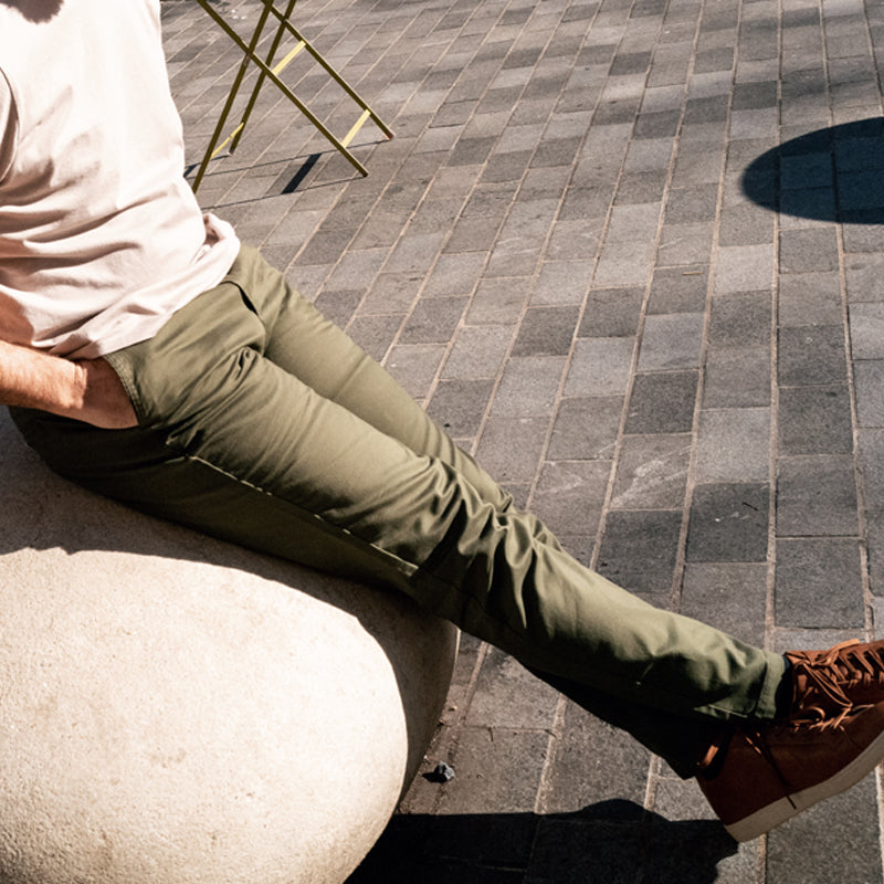 A pair of olive camo chinos designed for active men, showcasing a slim tapered fit and comfortable fabric.