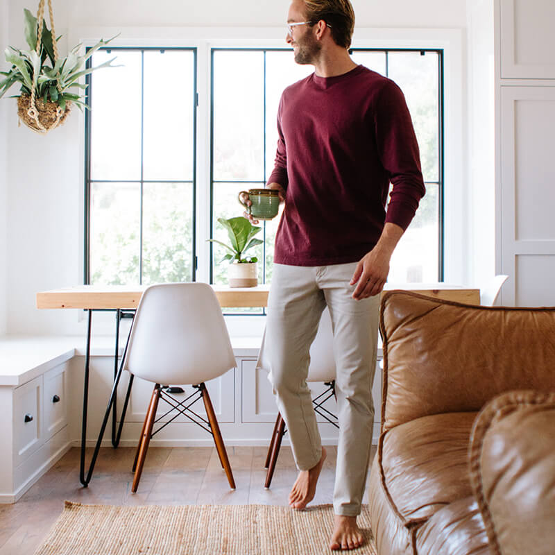 A pair of light khaki chinos designed for comfort and style, featuring a slim tapered fit and a curved waist for added comfort.