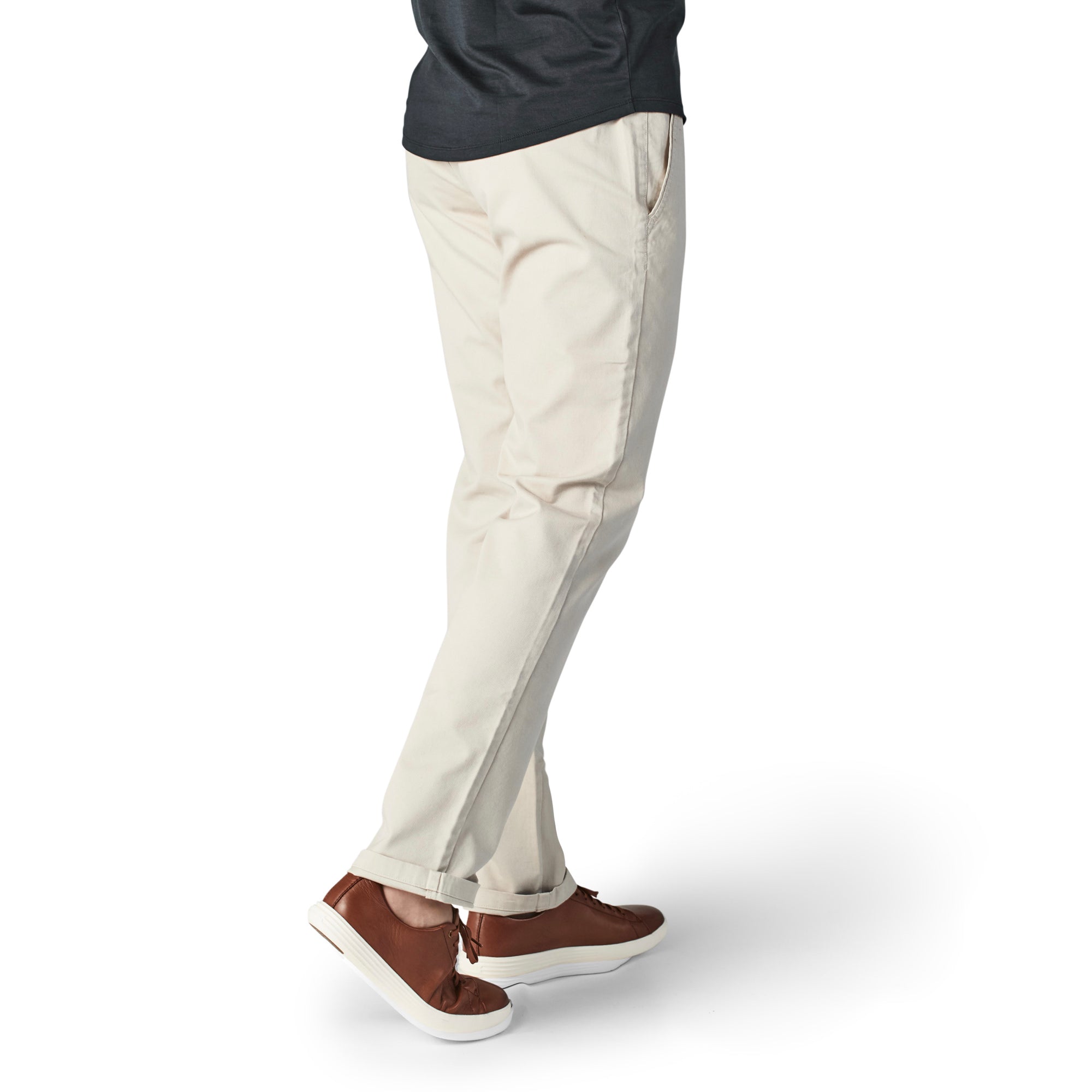 A pair of light khaki chinos designed for comfort and style, featuring a slim tapered fit and a curved waist for added comfort.