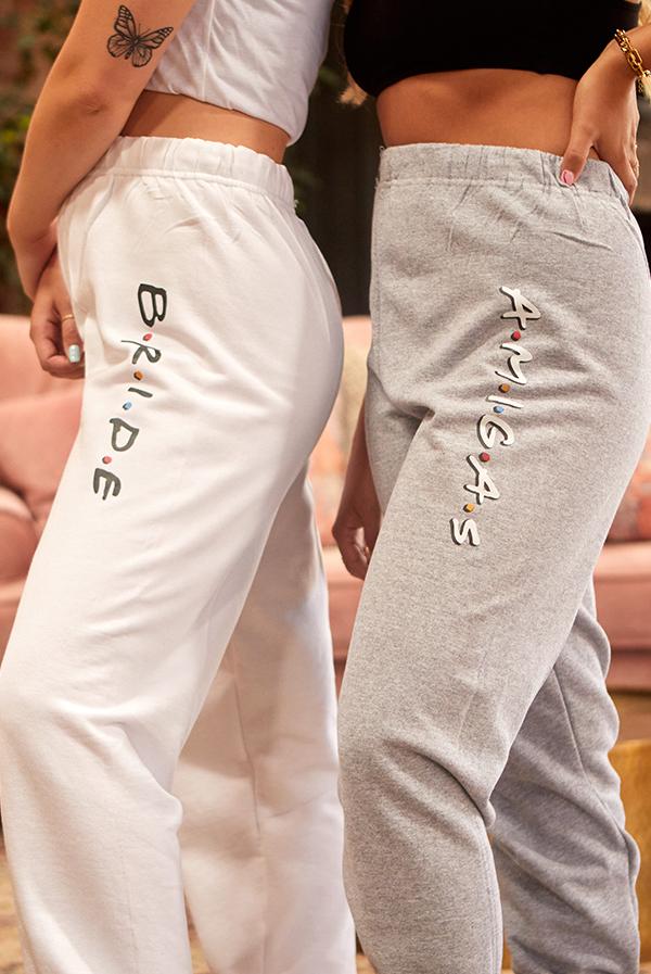 White and gray joggers with 'B.R.I.D.E' and 'A.M.I.G.A.S' text, perfect for bachelorette parties.