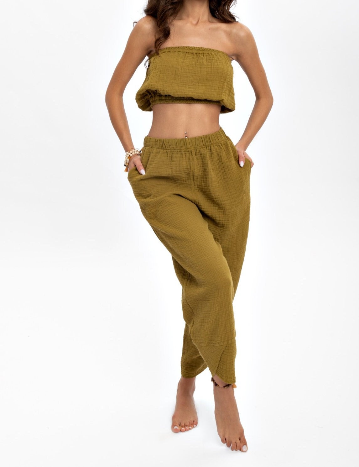 A pair of hand woven organic cotton pants in soft, natural colors, showcasing a high waist and elastic waistband, perfect for comfort and style.