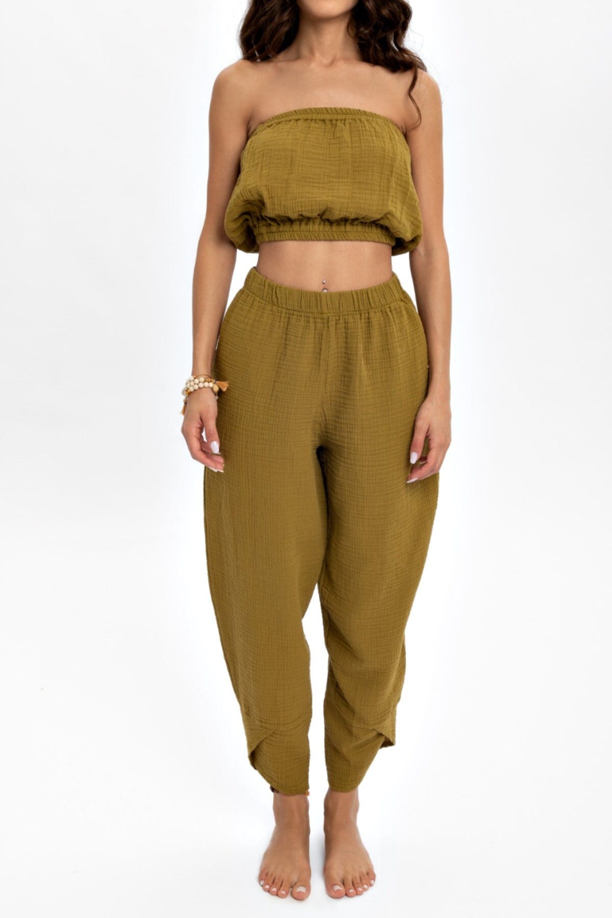 A pair of hand woven organic cotton pants in soft, natural colors, showcasing a high waist and elastic waistband, perfect for comfort and style.