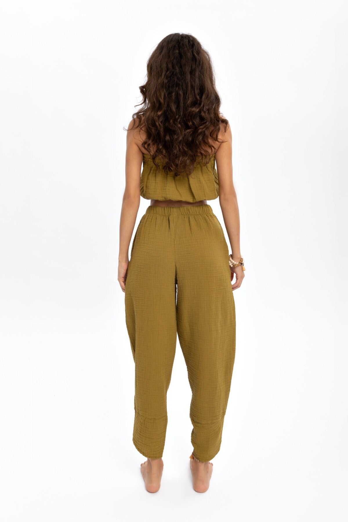 A pair of hand woven organic cotton pants in soft, natural colors, showcasing a high waist and elastic waistband, perfect for comfort and style.