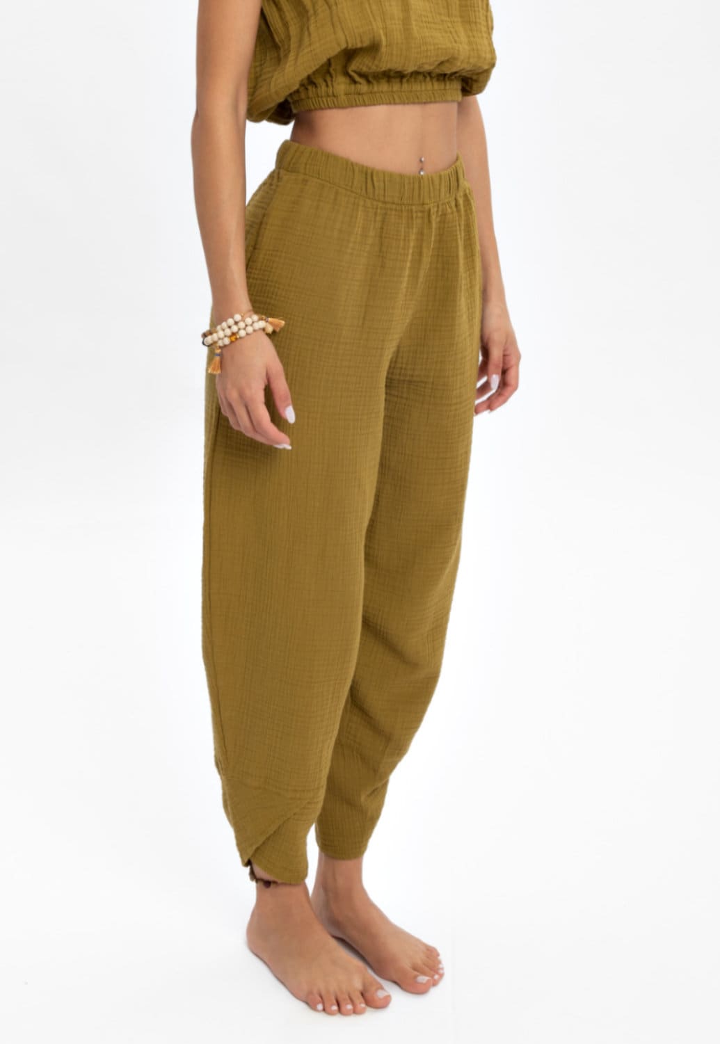 A pair of hand woven organic cotton pants in soft, natural colors, showcasing a high waist and elastic waistband, perfect for comfort and style.