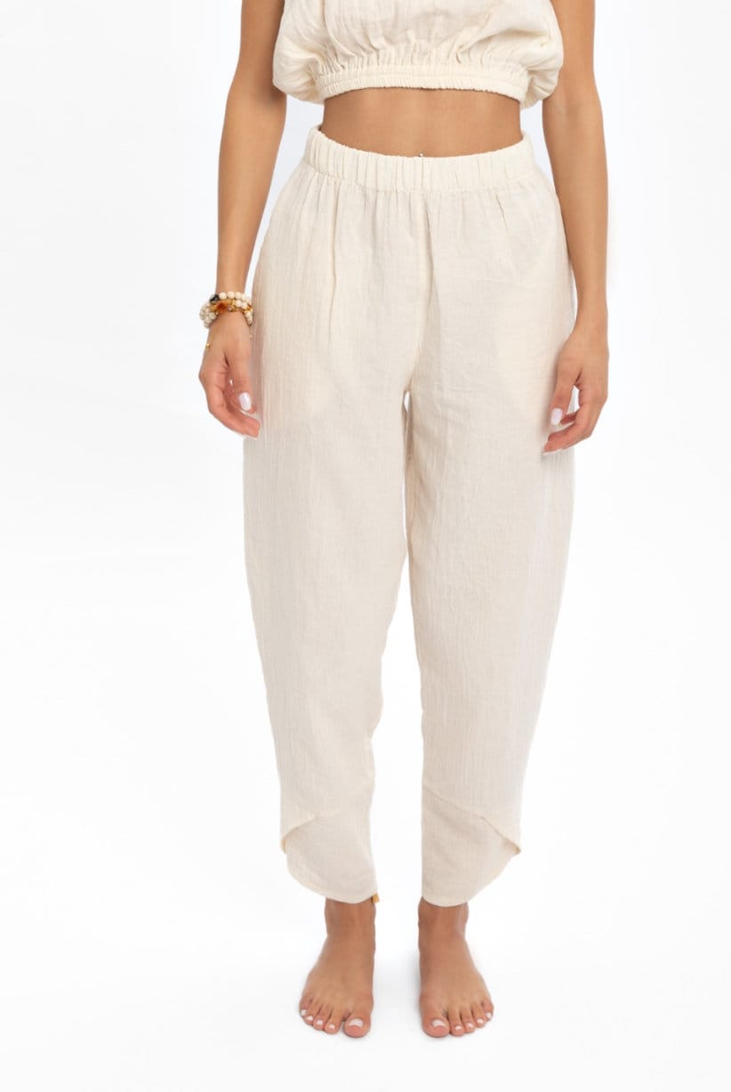 A pair of hand woven organic cotton pants in soft, natural colors, showcasing a high waist and elastic waistband, perfect for comfort and style.