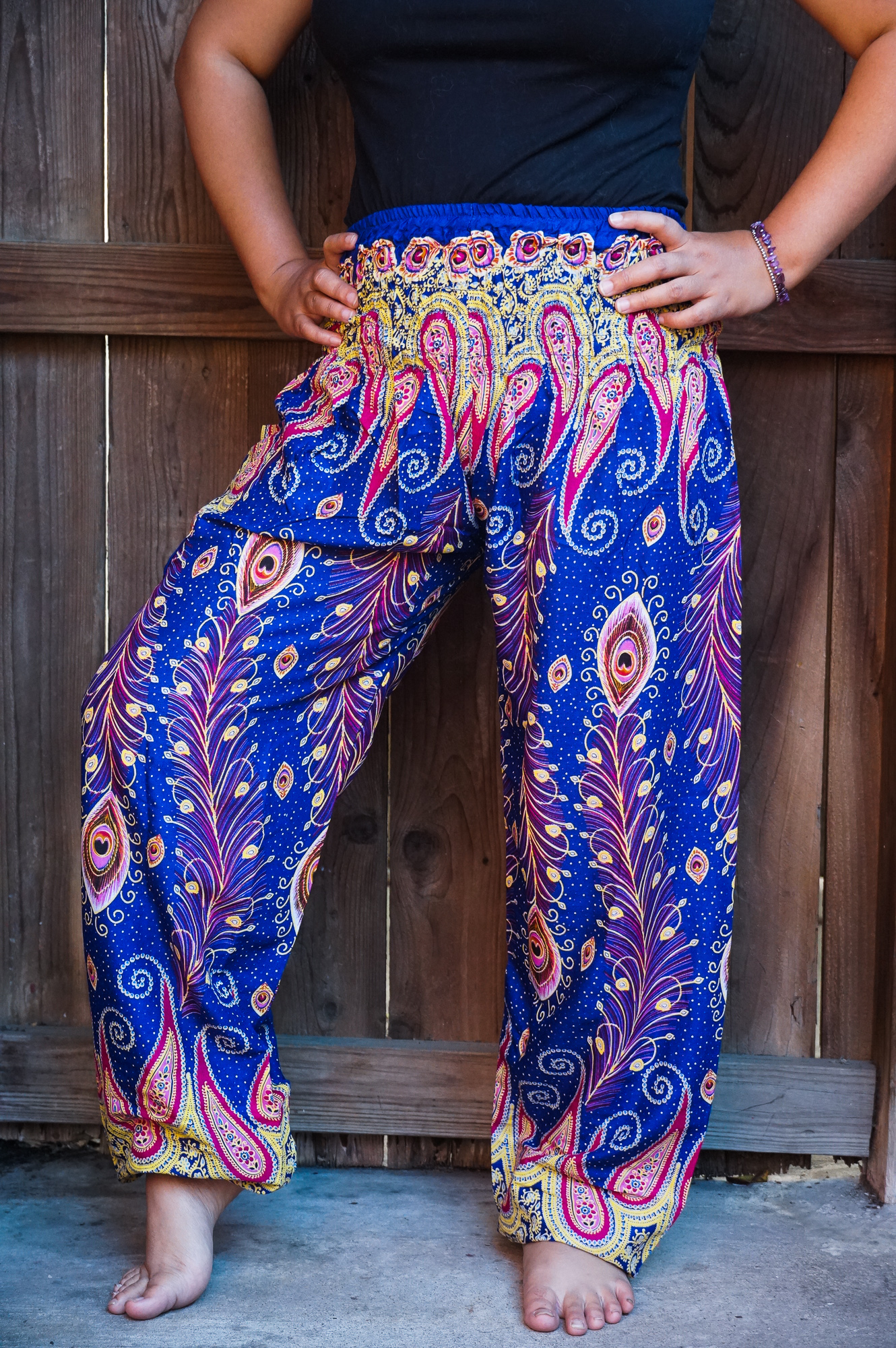 A pair of New Blue Peacock Boho Hippie Gypsy Pants featuring a vibrant peacock pattern, made from lightweight rayon fabric, showcasing their elastic waist and ankle design.