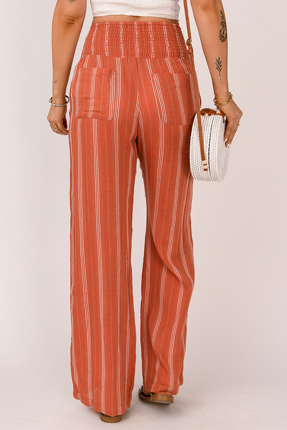 A pair of stylish orange high waist straight leg pants with a chic striped print, designed for a flattering fit and versatile wear.