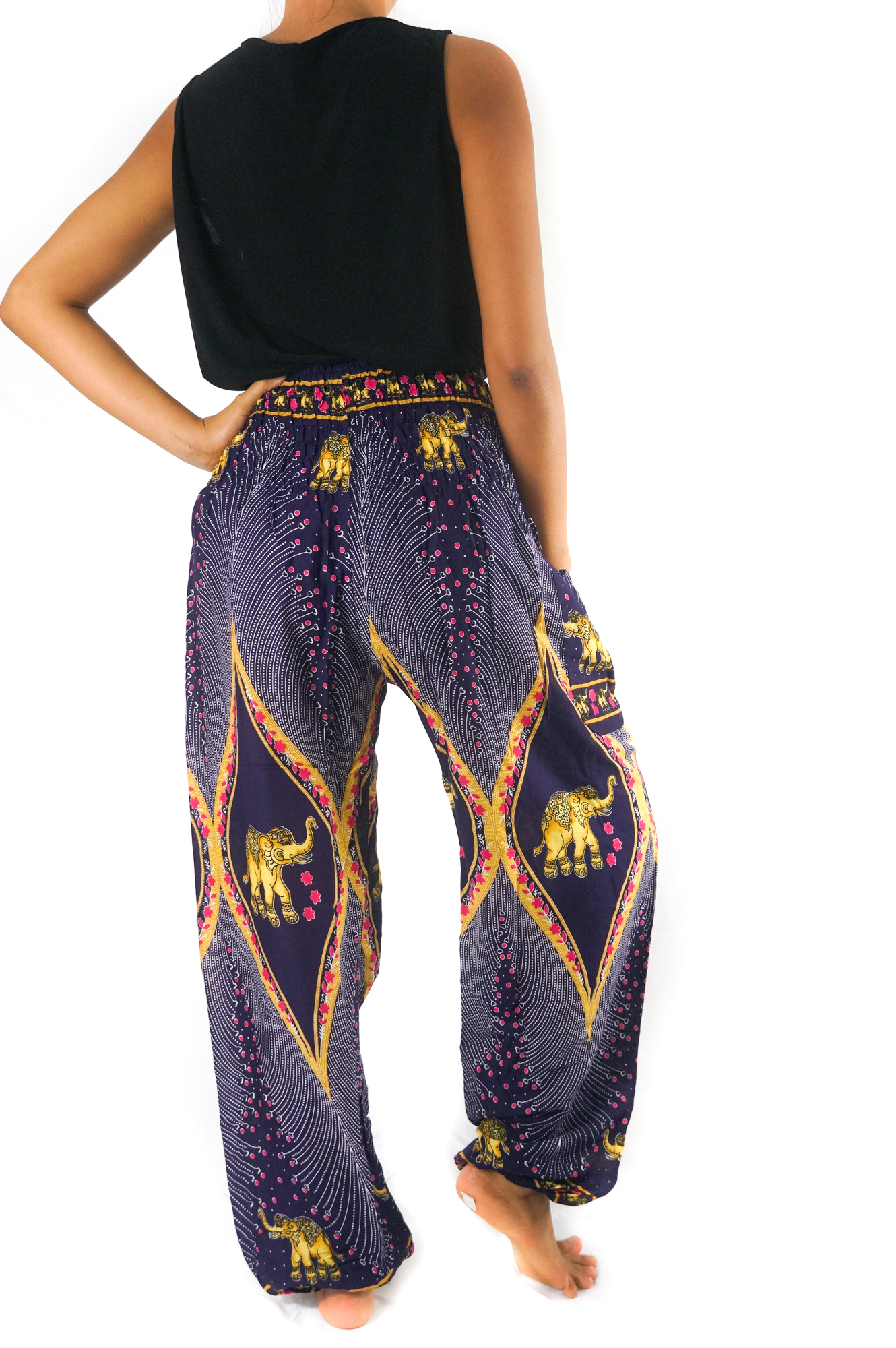 A pair of vibrant purple boho harem pants featuring intricate peacock and elephant patterns, made from lightweight rayon with an elastic waist and ankle.