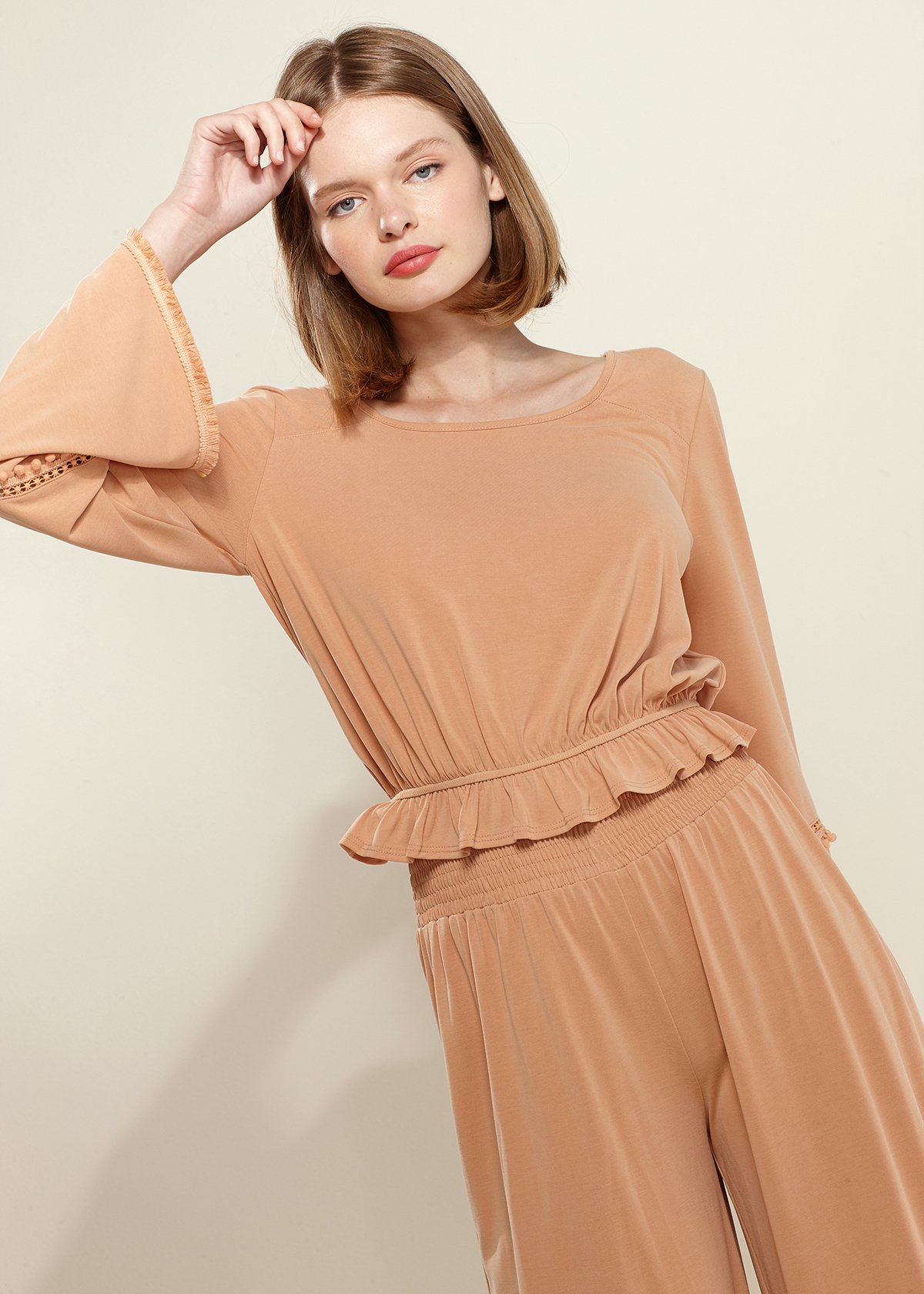 Smocked Waist Wide Leg Palazzo Pants in Apricot, showcasing a stylish design with a smocked waist and wide legs, made from soft cupro knit fabric.