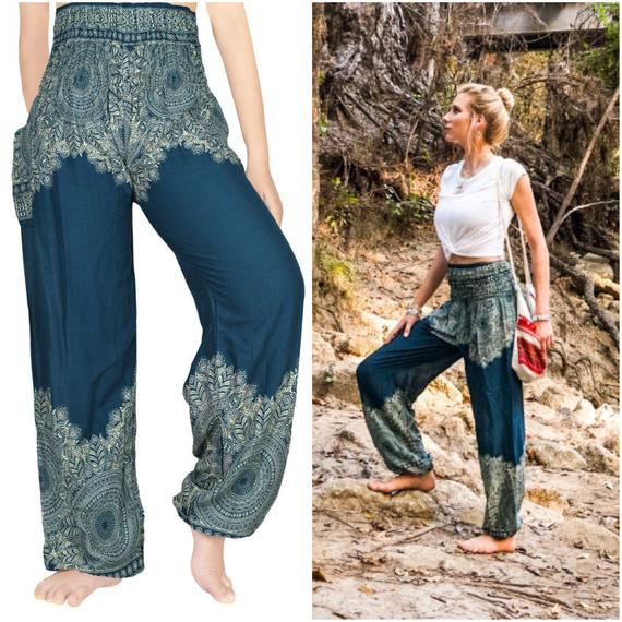 Teal floral women boho pants made of 100% rayon, featuring an elastic waist and ankle, one side pocket, and a vibrant floral pattern.