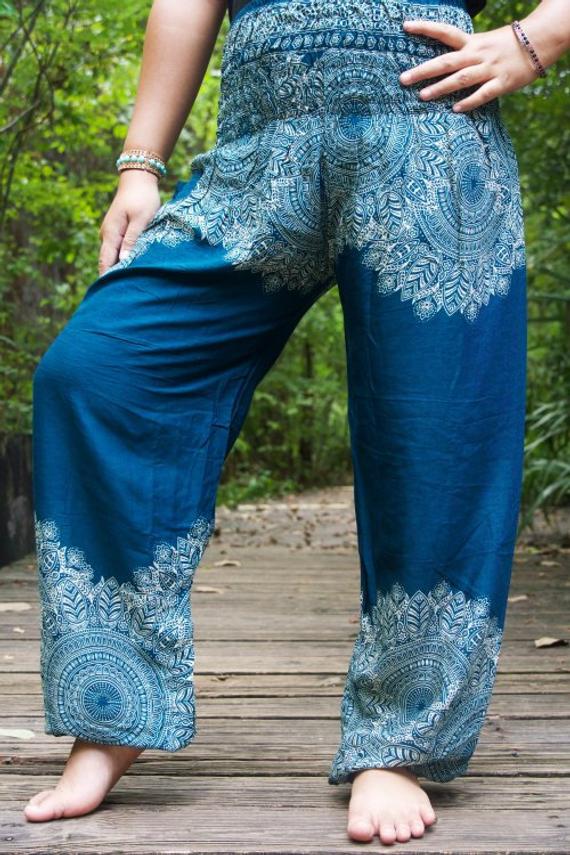 Teal floral women boho pants made of 100% rayon, featuring an elastic waist and ankle, one side pocket, and a vibrant floral pattern.