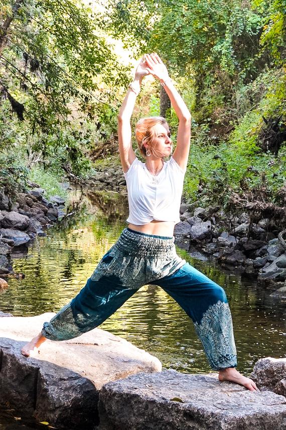 Teal floral women boho pants made of 100% rayon, featuring an elastic waist and ankle, one side pocket, and a vibrant floral pattern.