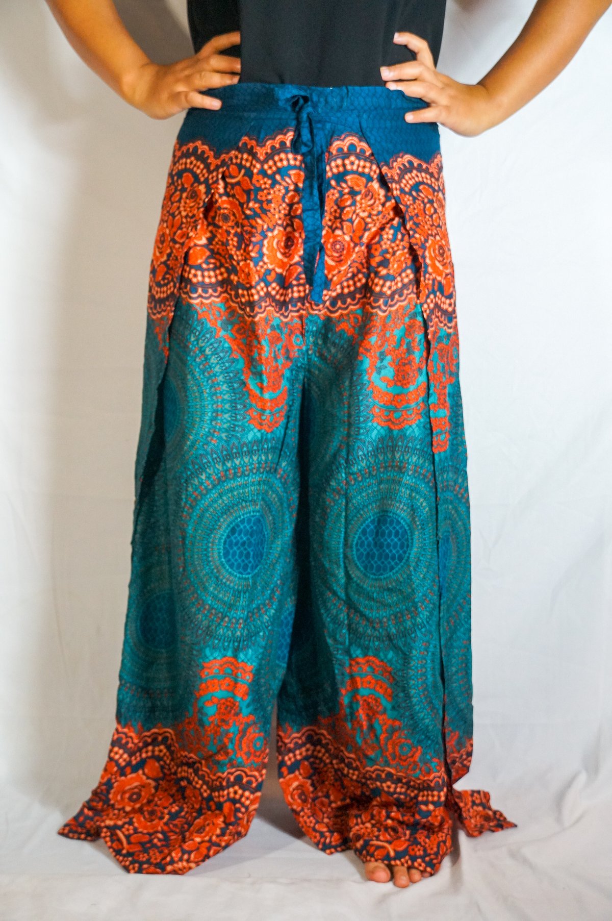 Teal Palazzo Wrap Pants featuring a tie-dye pattern, open leg design, and two connected panels for a bohemian look.