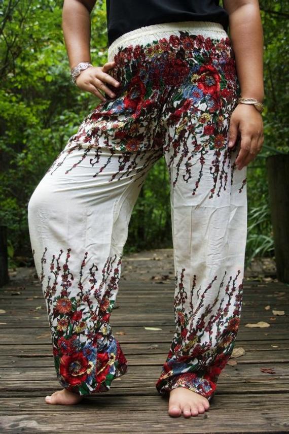 A pair of White Floral Women Boho Pants featuring a vibrant floral pattern, elastic waist, and ankle cuffs, perfect for yoga and casual wear.