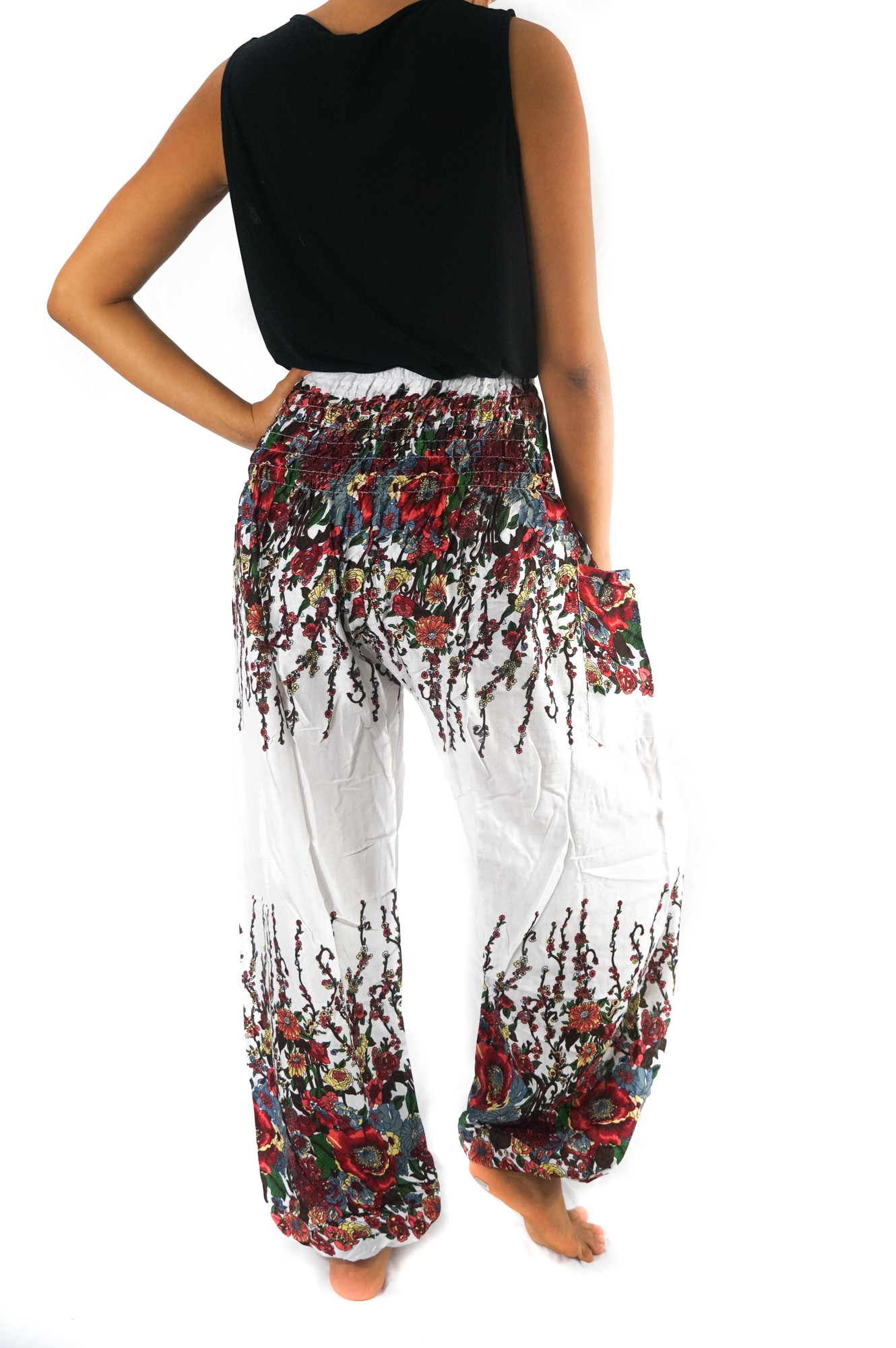 A pair of White Floral Women Boho Pants featuring a vibrant floral pattern, elastic waist, and ankle cuffs, perfect for yoga and casual wear.