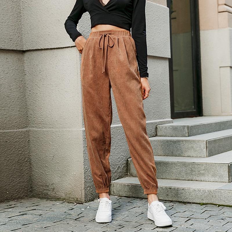 Women fashion high waist harem pants in solid brown, featuring an elastic waist and stylish sashes, perfect for casual wear.