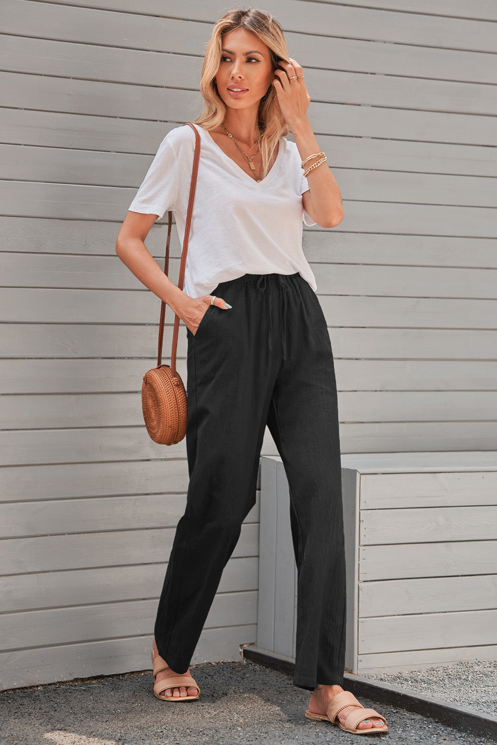 Women's black drawstring pants with elastic waist and pockets, featuring straight legs for a casual look.