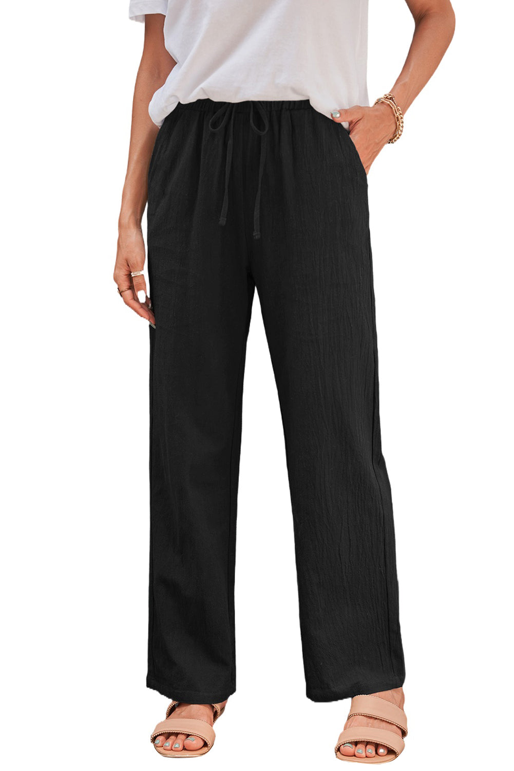 Women's black drawstring pants with elastic waist and pockets, featuring straight legs for a casual look.