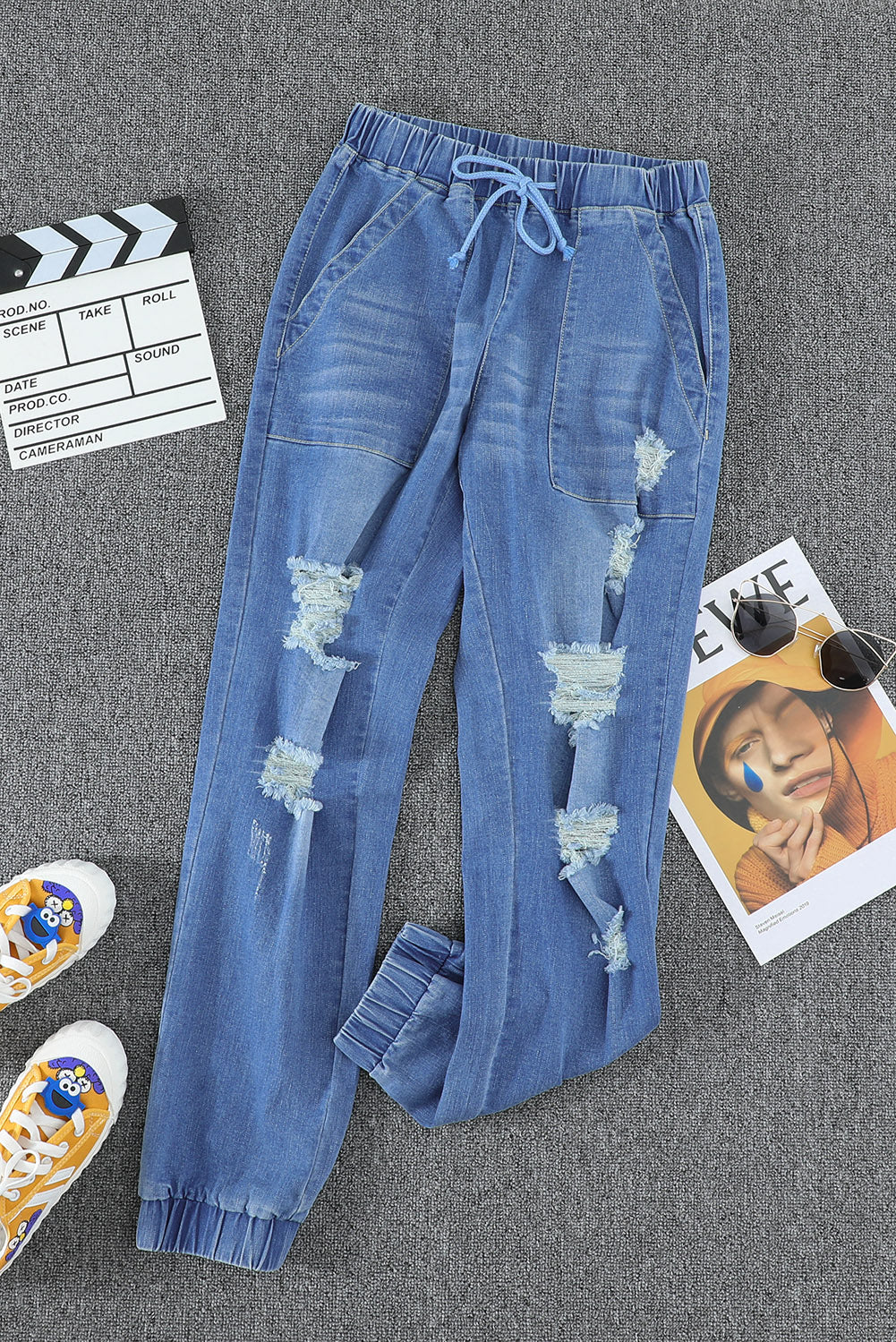 A pair of women's sky blue pocketed distressed jean joggers featuring an elastic waistband and stylish ripped design.