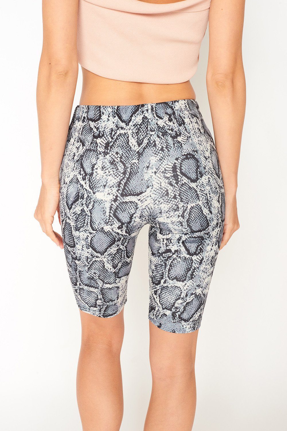 A pair of stylish snake print biker shorts featuring a body-conscious fit and a medium to high waist, perfect for casual or active wear.