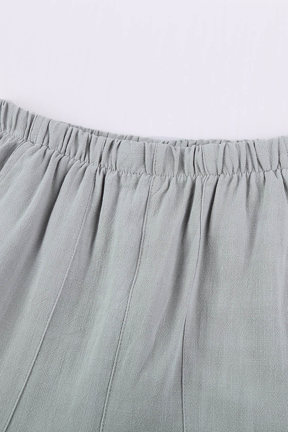 A pair of stylish gray blue pocketed flutter linen cotton shorts with ruffled details, perfect for summer wear.