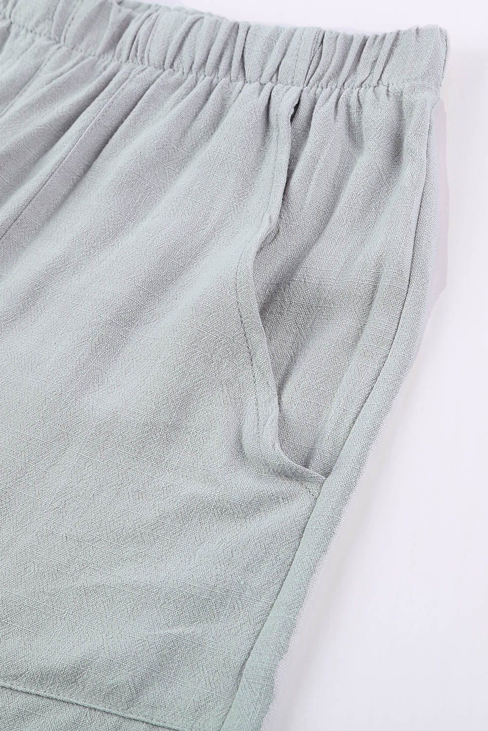 A pair of stylish gray blue pocketed flutter linen cotton shorts with ruffled details, perfect for summer wear.