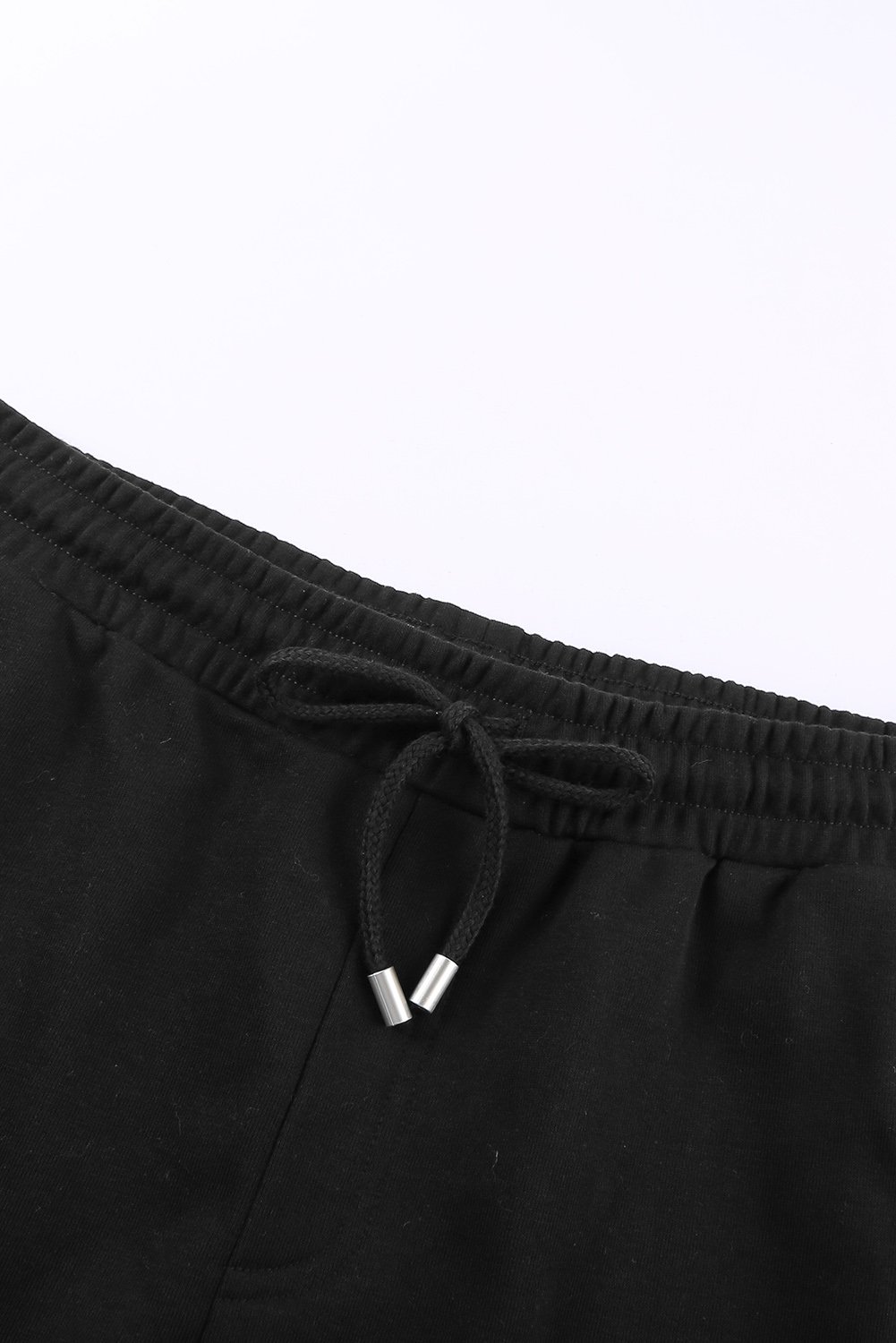 A pair of stylish black cuffed lounge shorts for women featuring a tie waist and side pockets, perfect for summer wear.