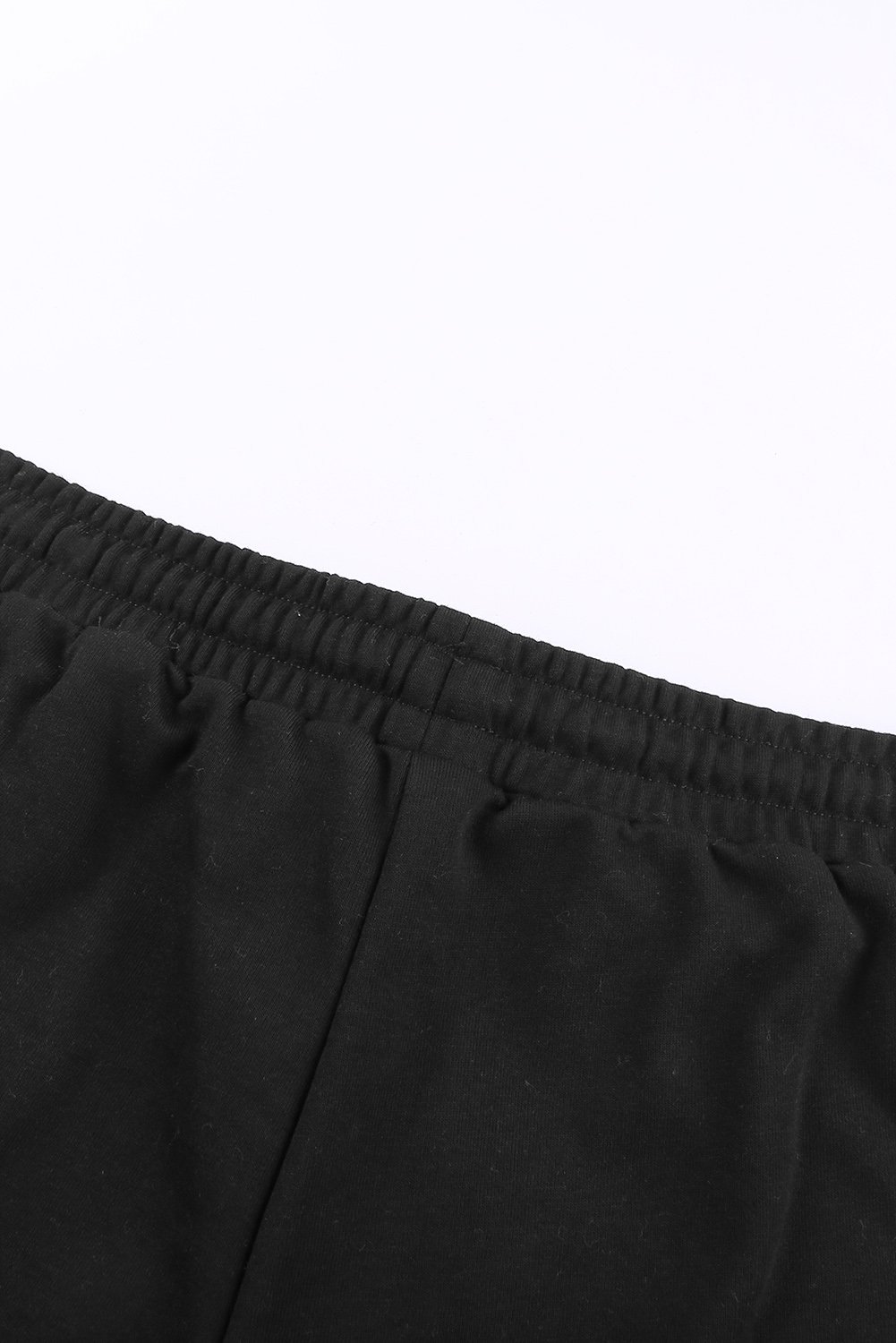 A pair of stylish black cuffed lounge shorts for women featuring a tie waist and side pockets, perfect for summer wear.