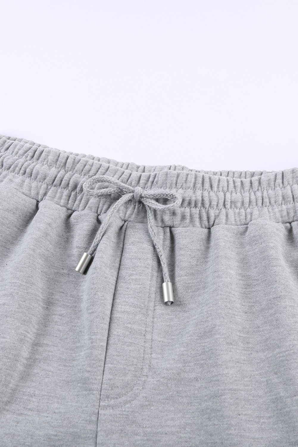 A pair of gray cuffed lounge shorts for women featuring a tie waist and side pockets, perfect for summer wear.