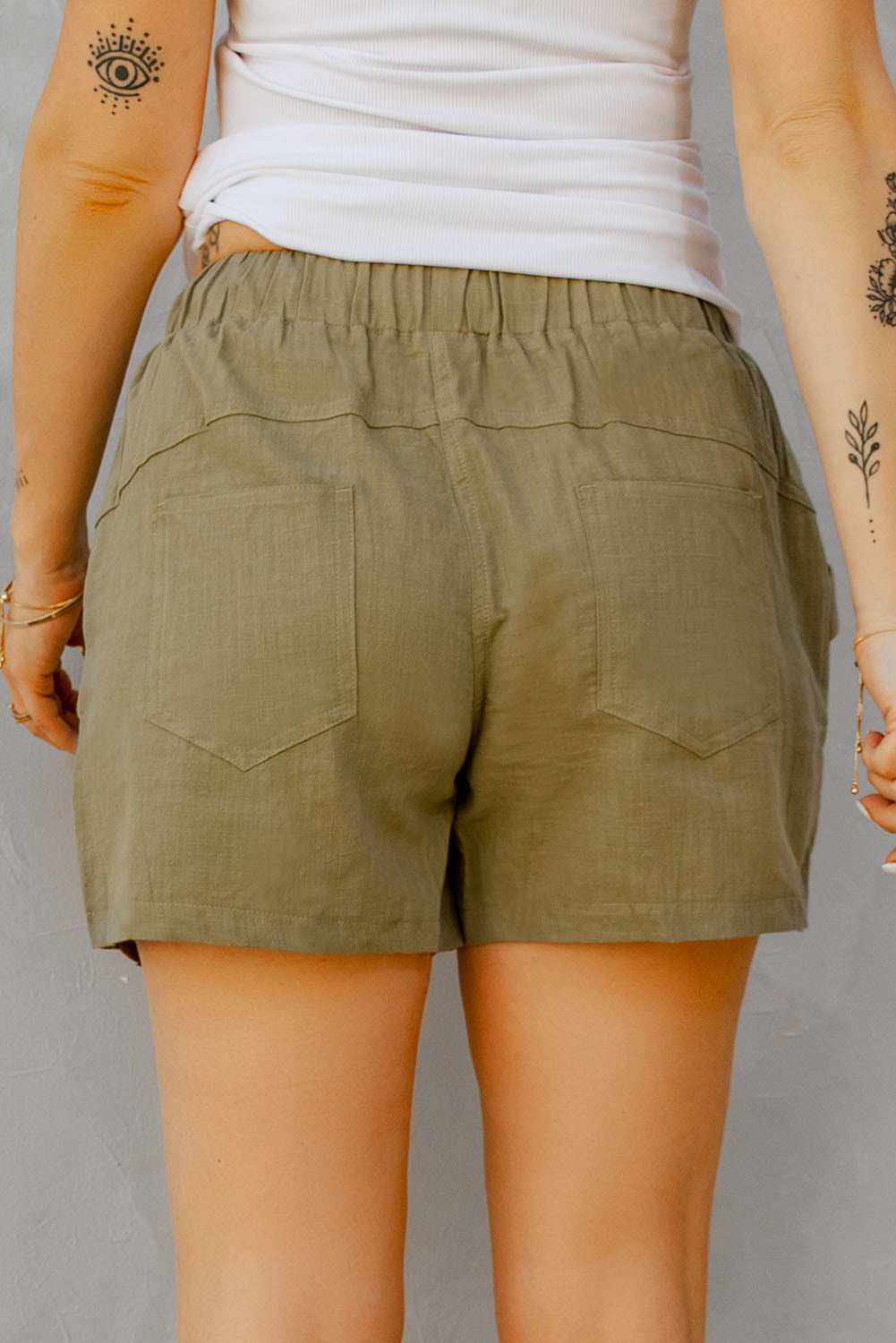 A pair of stylish green women shorts made from 100% cotton, featuring an elasticised waist with drawstring and pockets on both sides.