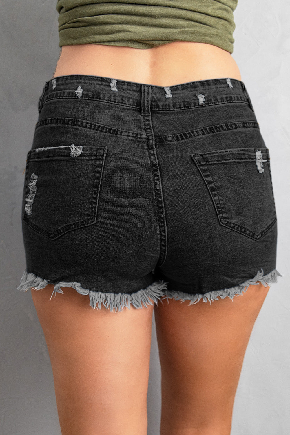 A pair of Women's Black Gypsy Mid-rise Distressed Denim Shorts featuring heavy distressing, a frayed hem, and a classic five-pocket design, perfect for summer wear.