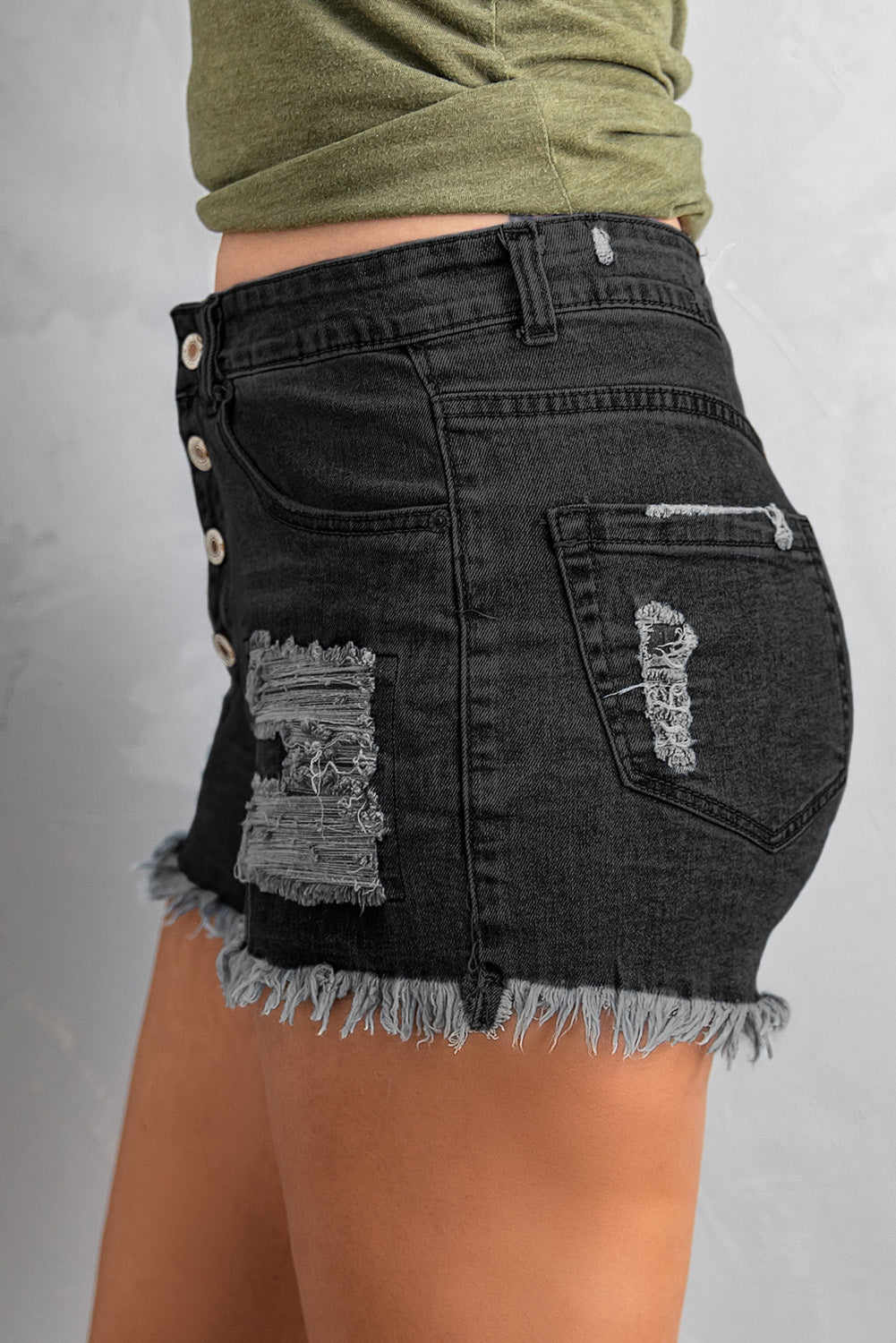 A pair of Women's Black Gypsy Mid-rise Distressed Denim Shorts featuring heavy distressing, a frayed hem, and a classic five-pocket design, perfect for summer wear.