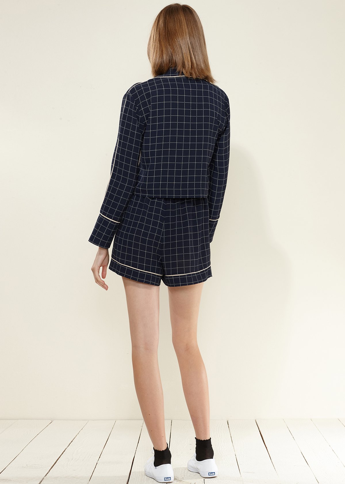 Women's navy plaid high shorts featuring a grid print, contrast trim, and a waist tie for a stylish fit.