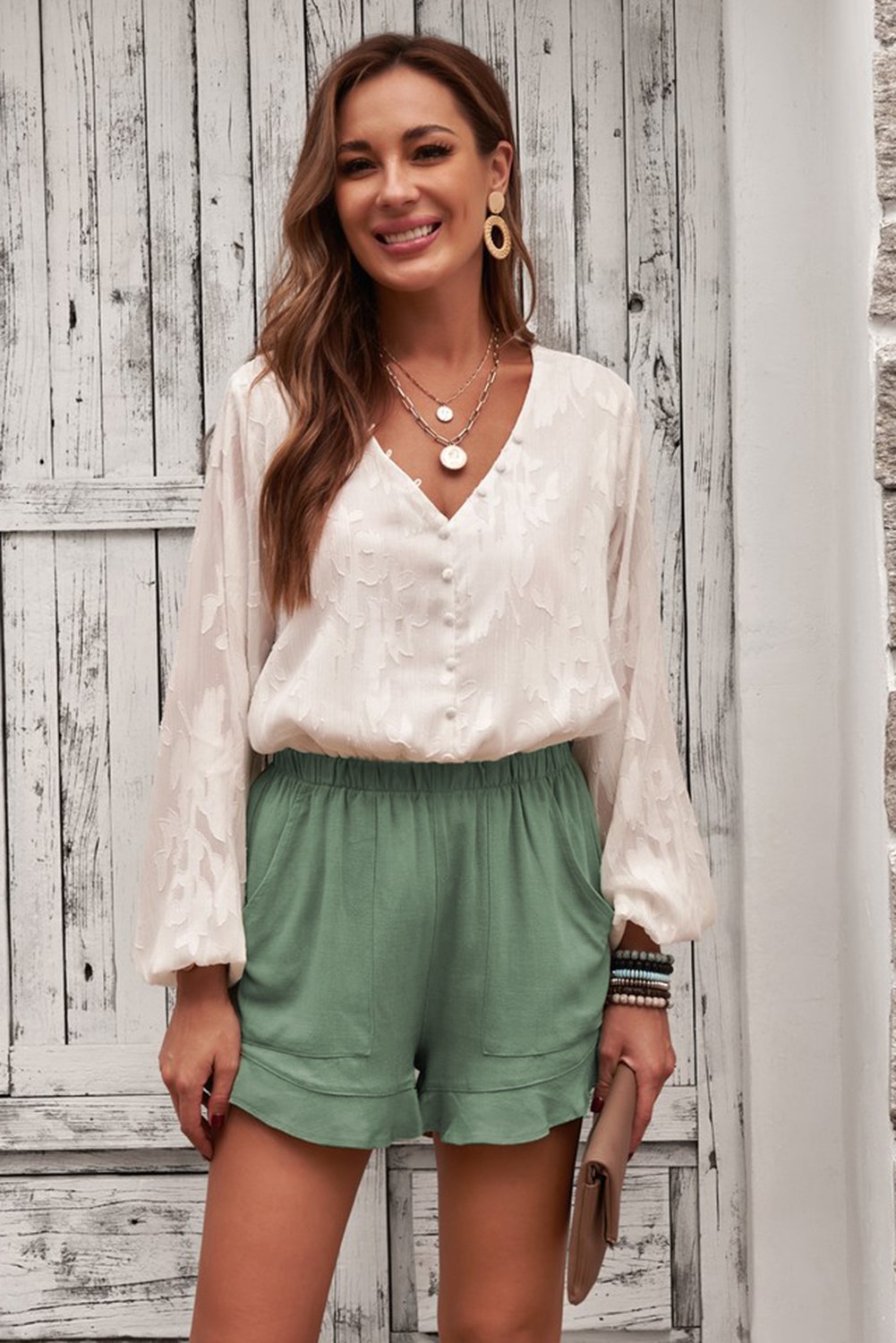 A pair of Women's Summer Pocketed Flutter Green Linen Cotton Shorts featuring ruffled details and side pockets, perfect for summer wear.