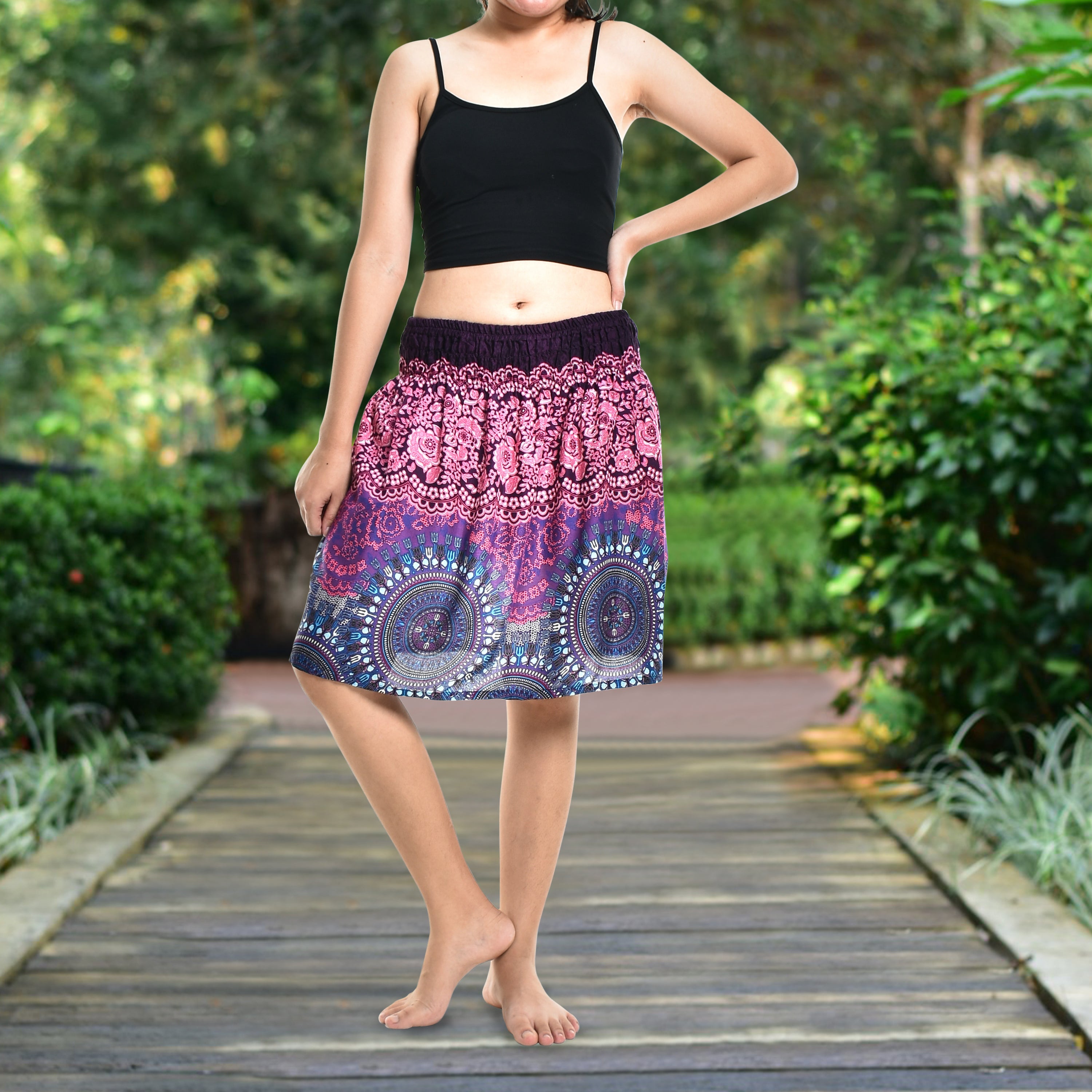 Bohotusk Pink Blue Sun Glow Print Short Skirt hanging on a display, showcasing its vibrant colors and elasticated waist.