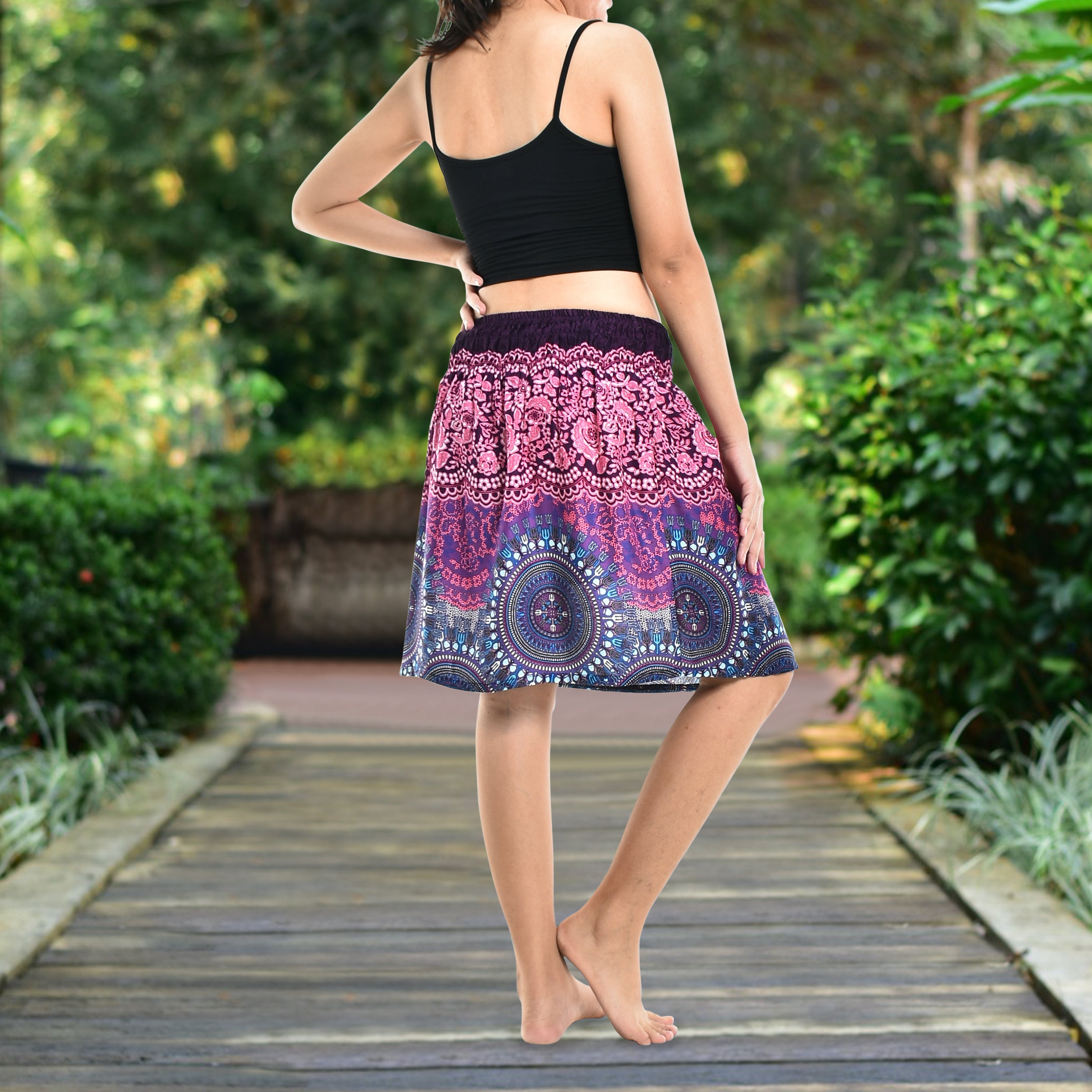 Bohotusk Pink Blue Sun Glow Print Short Skirt hanging on a display, showcasing its vibrant colors and elasticated waist.