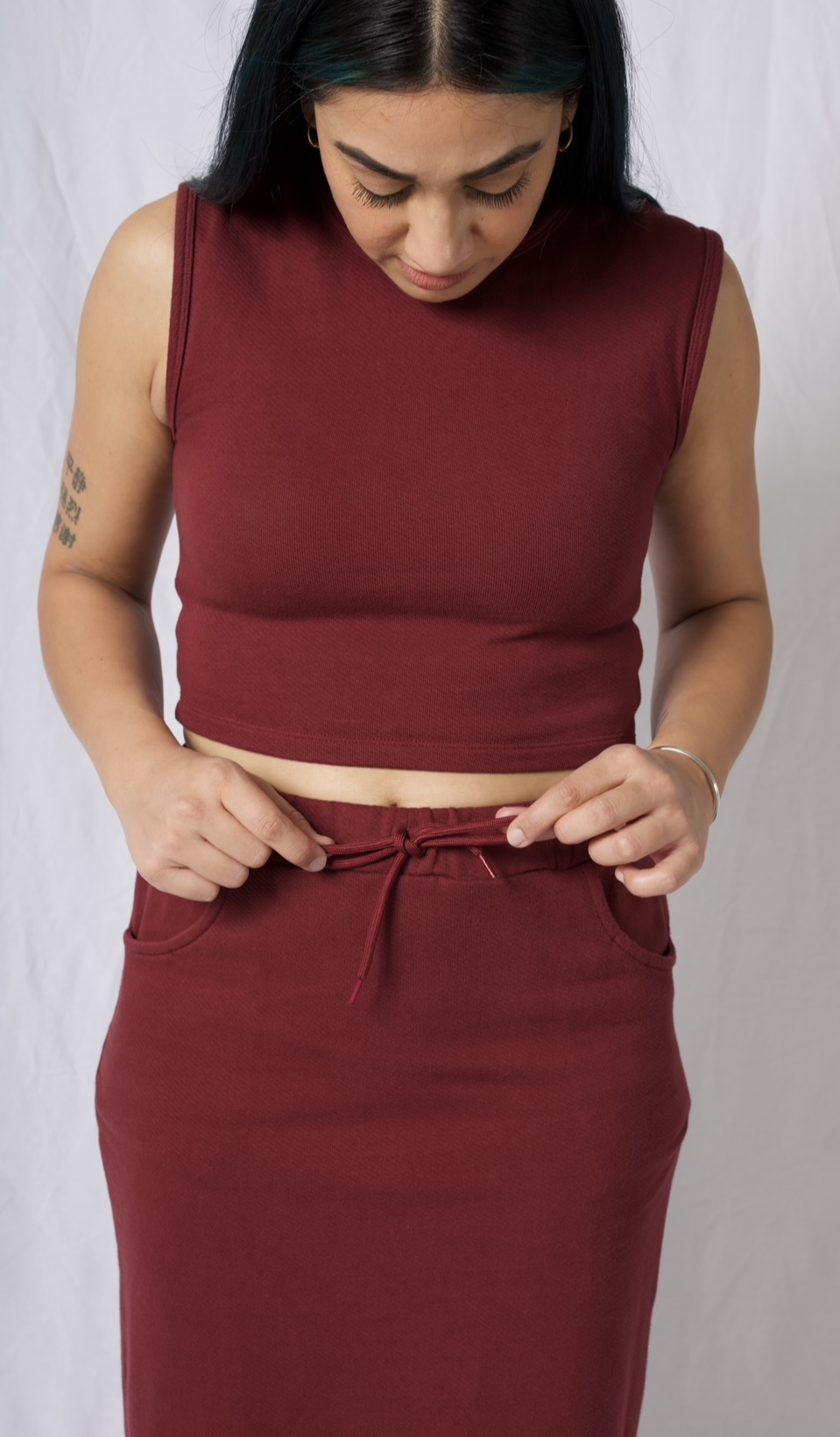 A stylish cotton midi skirt featuring an elastic waistband, deep pockets, and a braided brick red drawstring, perfect for versatile outfits.