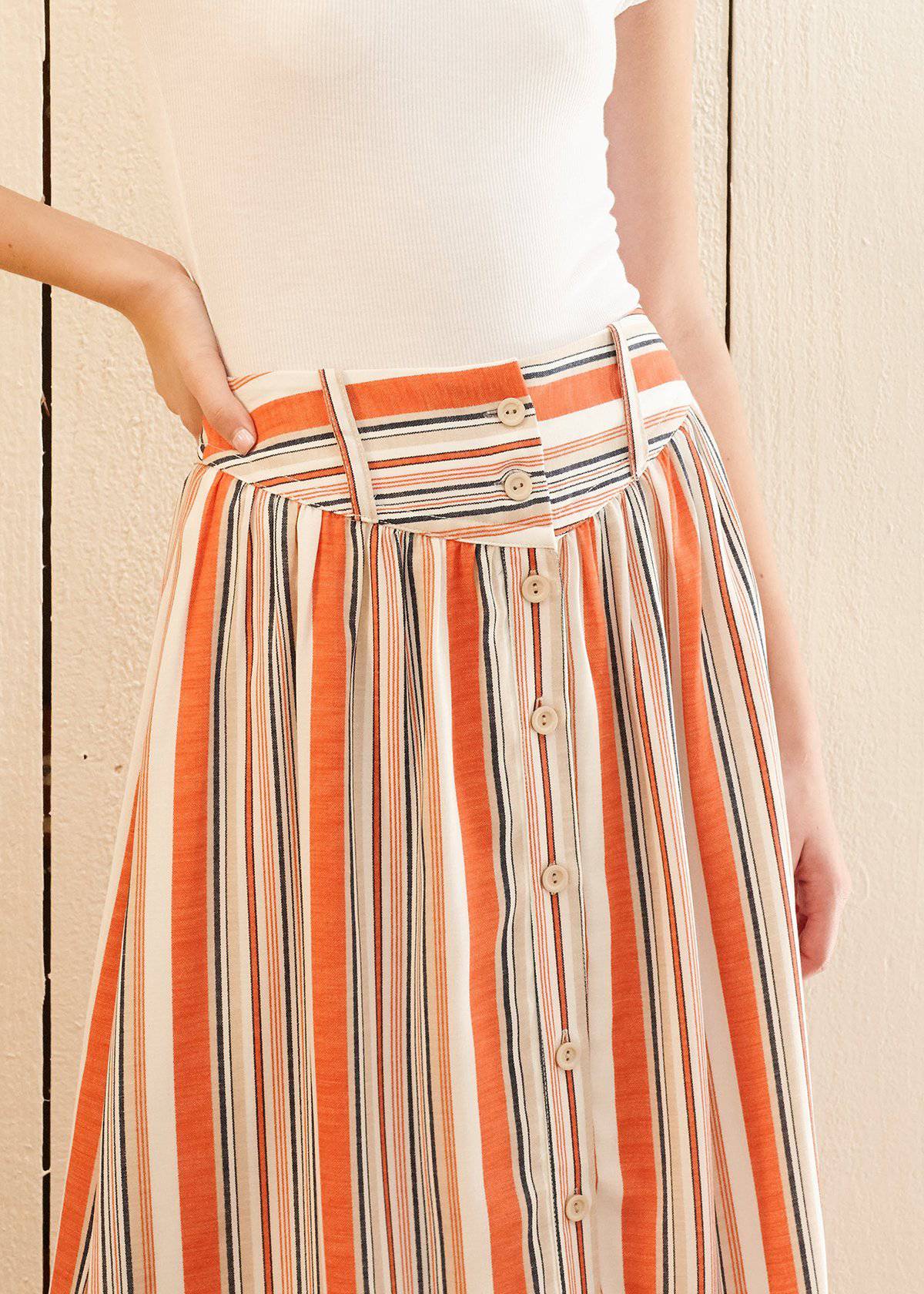 Women's Multi Stripe Button Front Midi Skirt in Rust Multi, featuring a stylish stripe pattern and front button closure, fully lined for comfort.