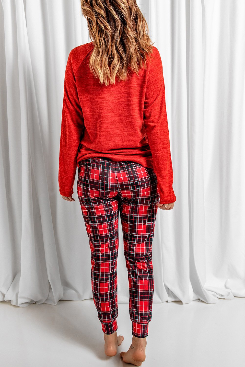 A cozy red lounge set featuring a plaid print, consisting of a full-sleeve top and matching pants, perfect for Valentine's Day and winter lounging.