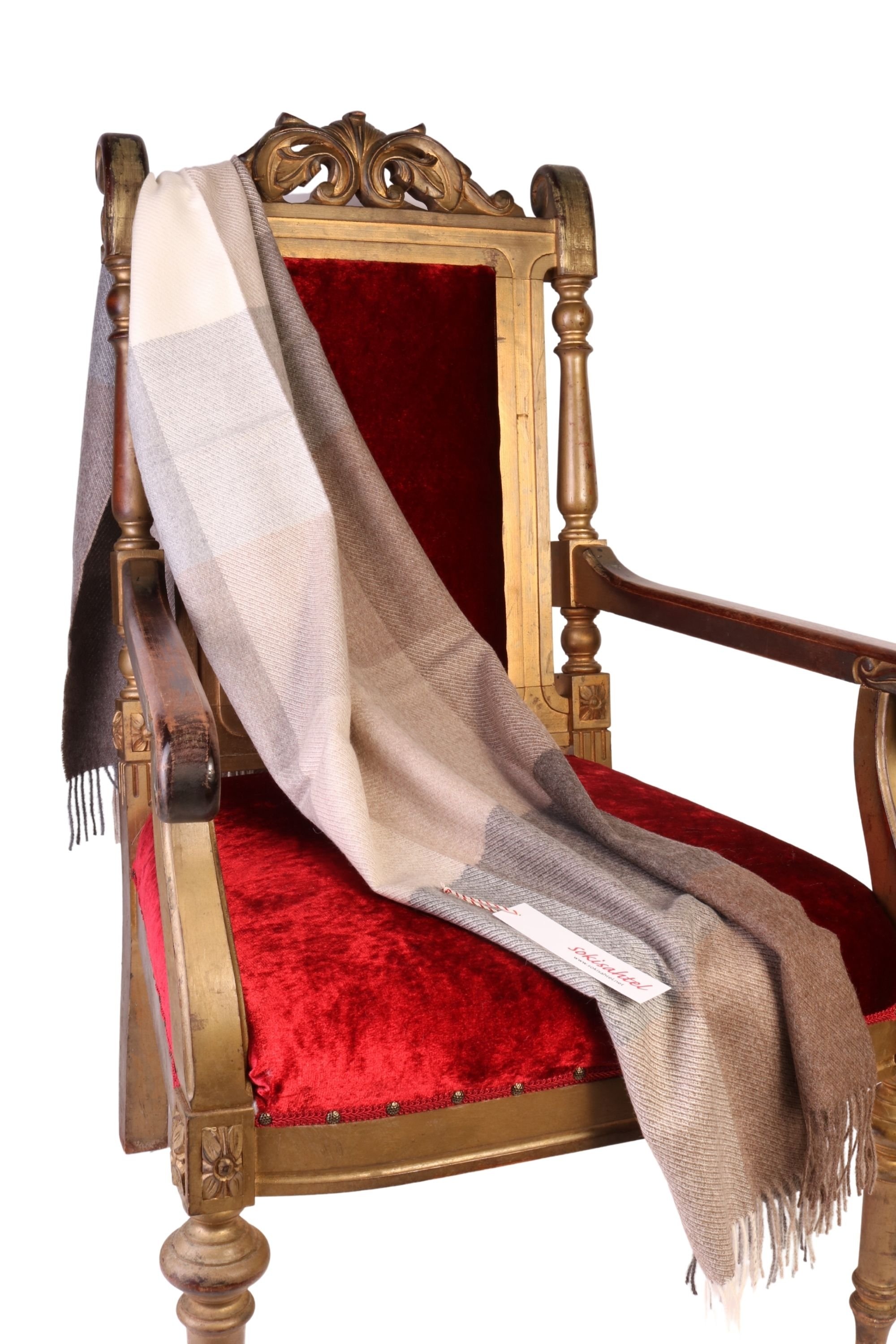 Beige-grey checked alpaca wool small plaid elegantly draped on a chair, showcasing its luxurious texture and warm colors.