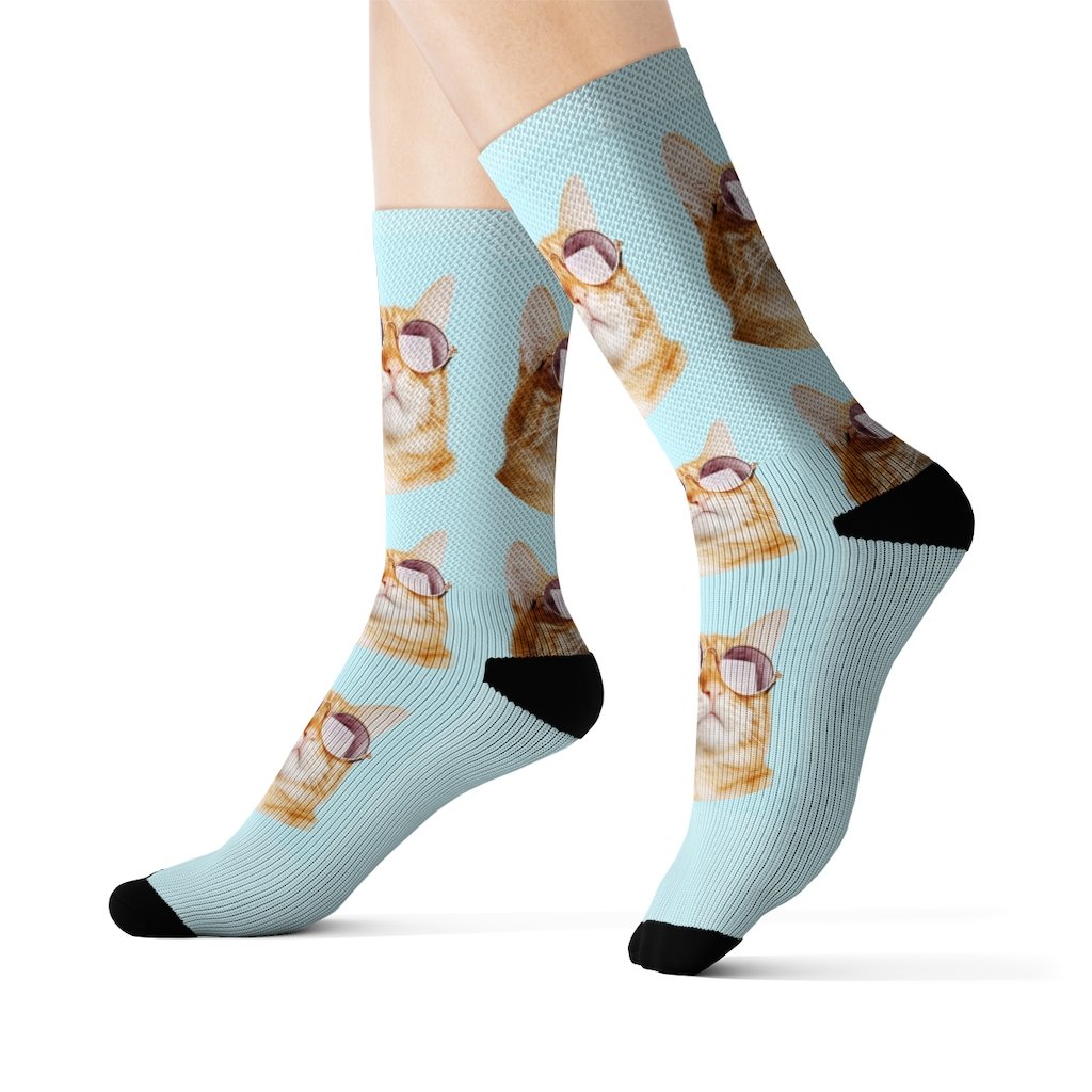 A pair of stylish socks featuring a playful cat wearing sunglasses, showcasing vibrant colors and a fun design.