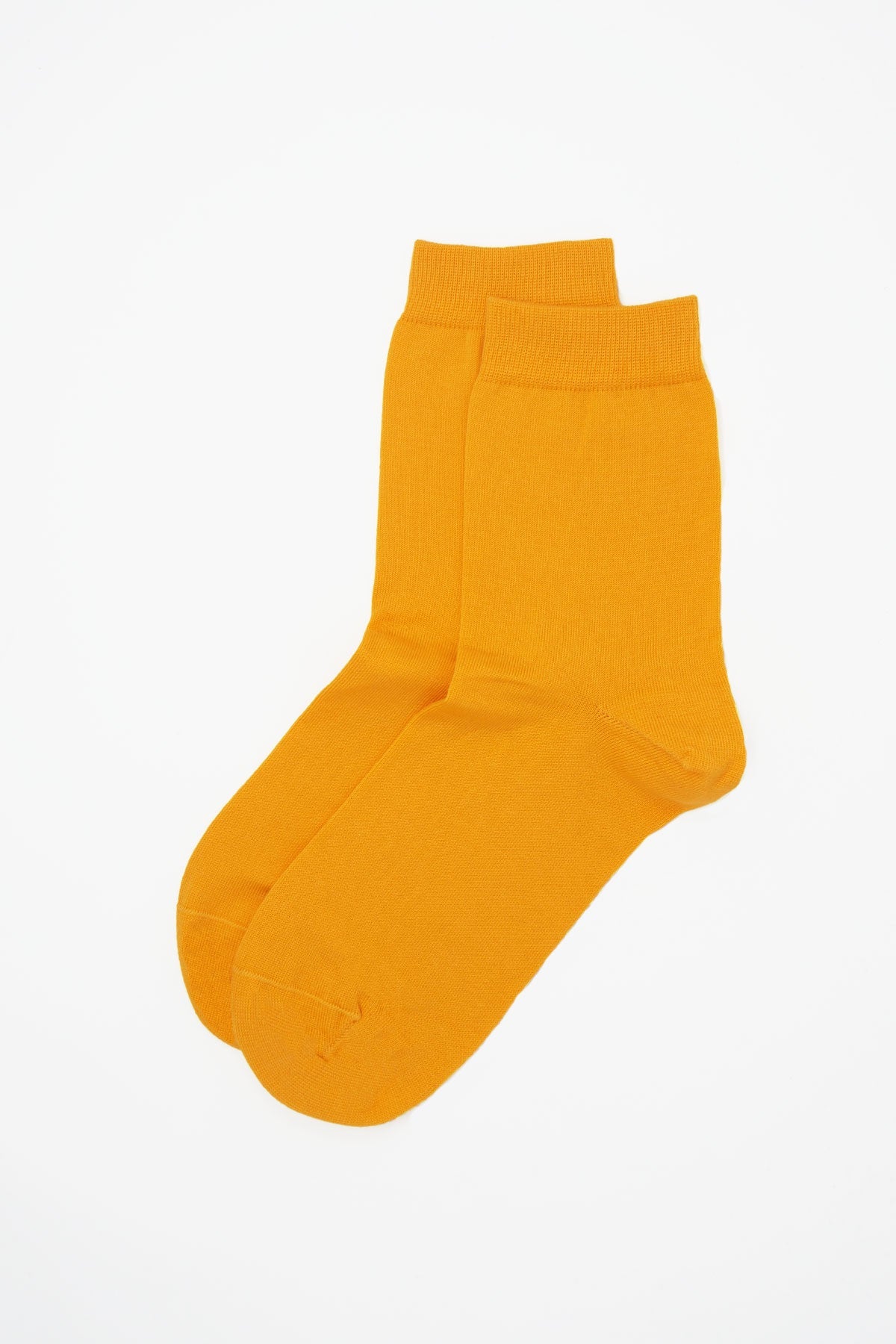 A pair of vibrant yellow classic women's socks made from luxurious Egyptian cotton, showcasing a seamless toe design.