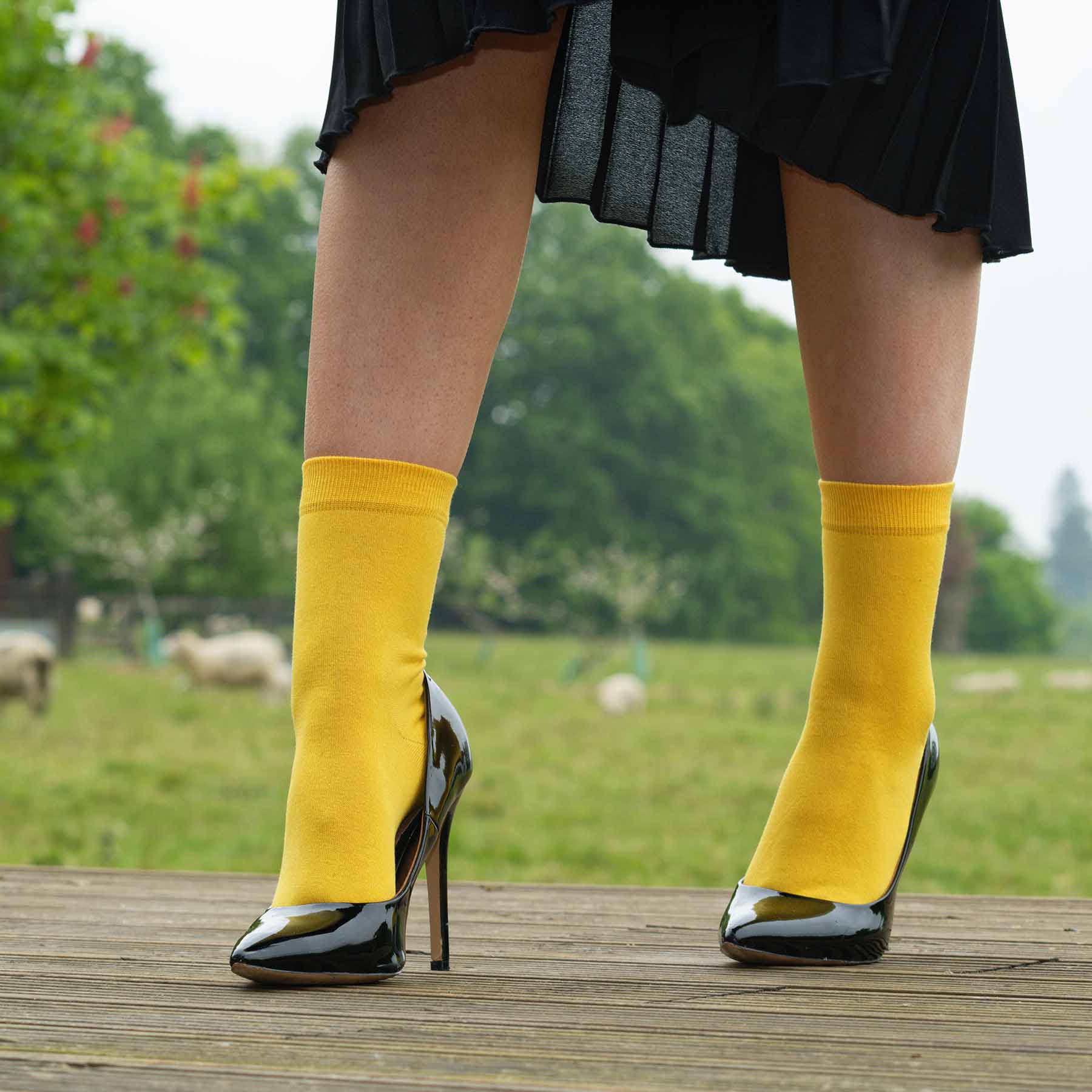 A pair of vibrant yellow classic women's socks made from luxurious Egyptian cotton, showcasing a seamless toe design.