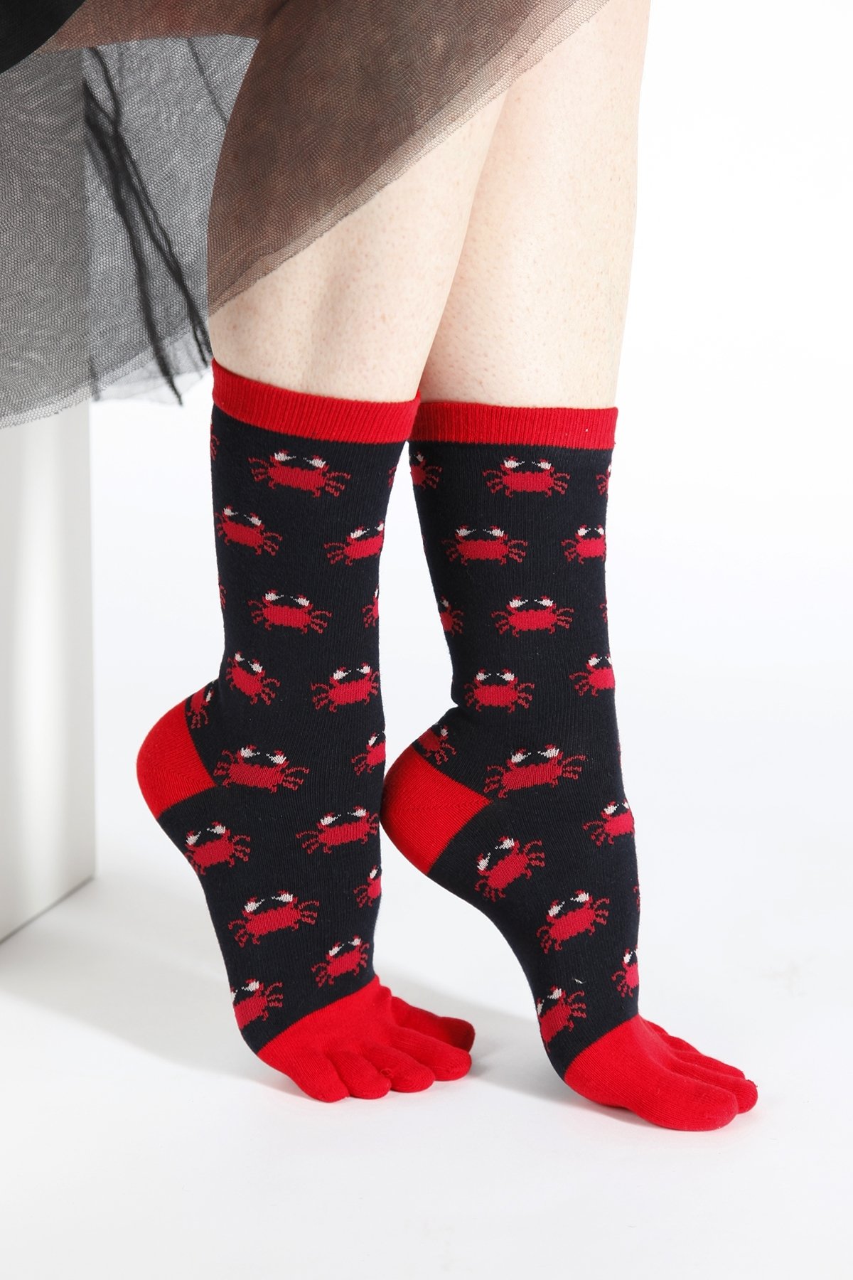 A pair of blue CRAB TOES toe socks for women featuring a playful crab pattern, showcasing their unique design and comfortable fit.