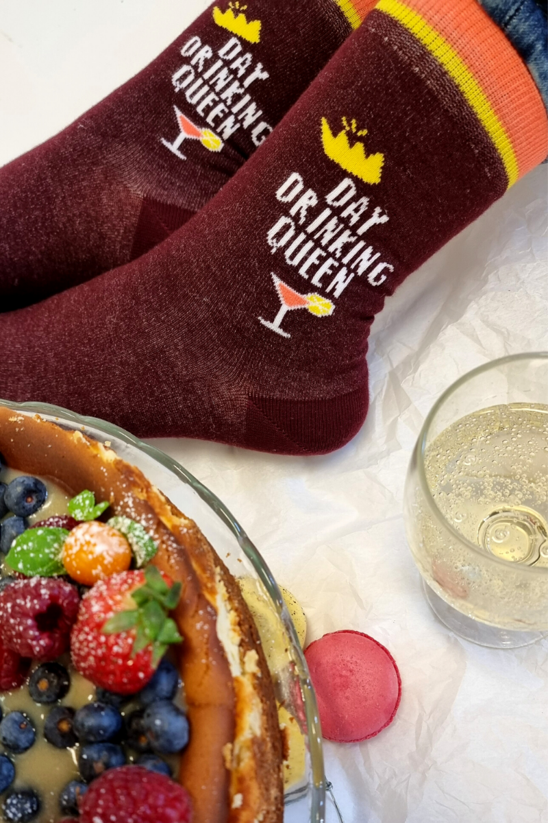 Burgundy socks for women featuring a cocktail glass design and the text 'DAY DRINKING QUEEN' on the side.