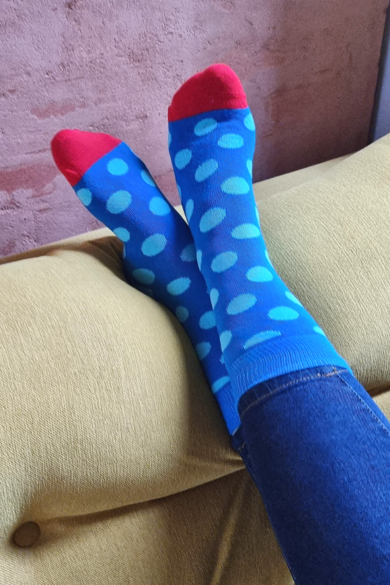 A pair of blue cotton socks featuring a playful polka dot pattern, suitable for both men and women.