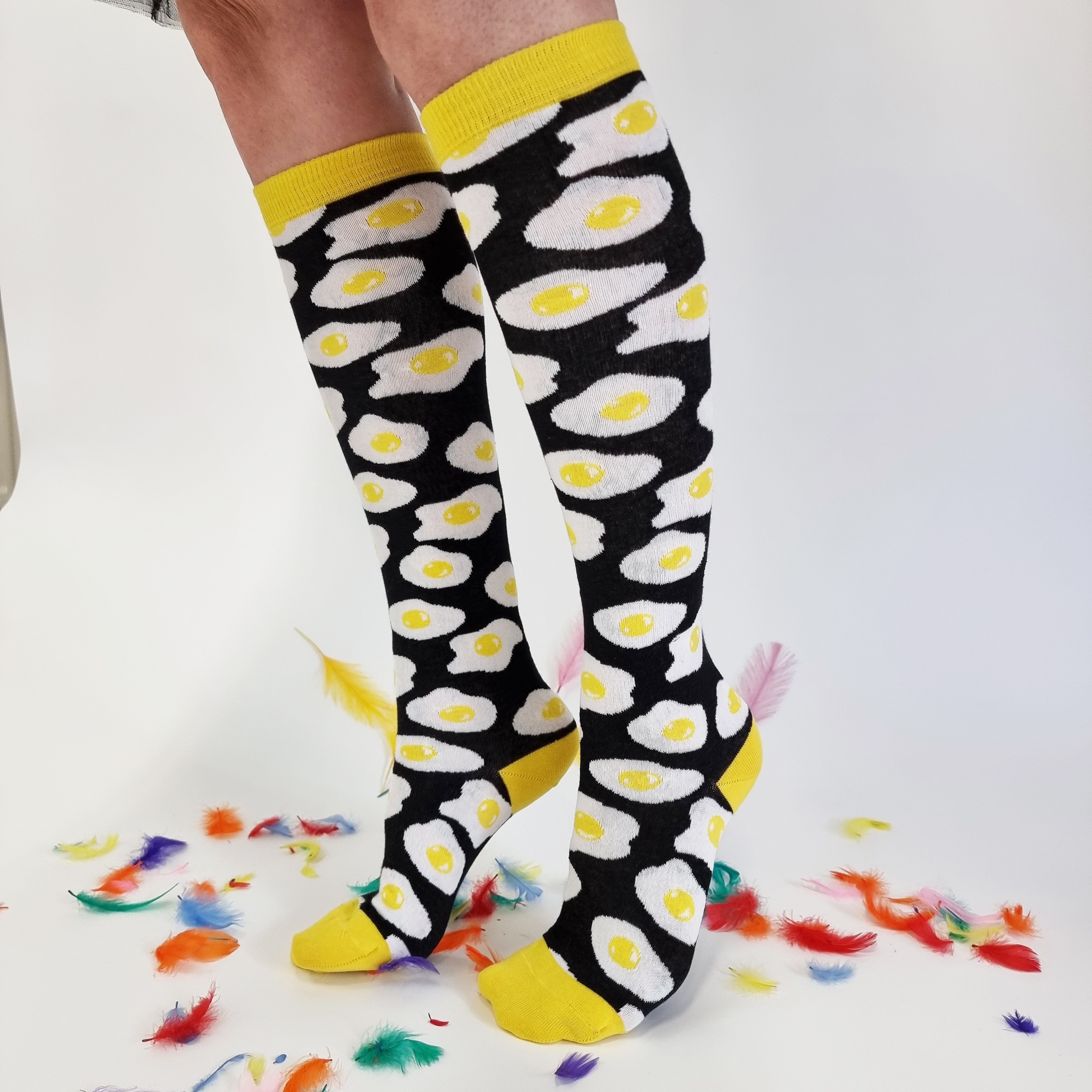 Black and yellow cotton knee-high socks featuring a sunny side up egg design, perfect for men and women.