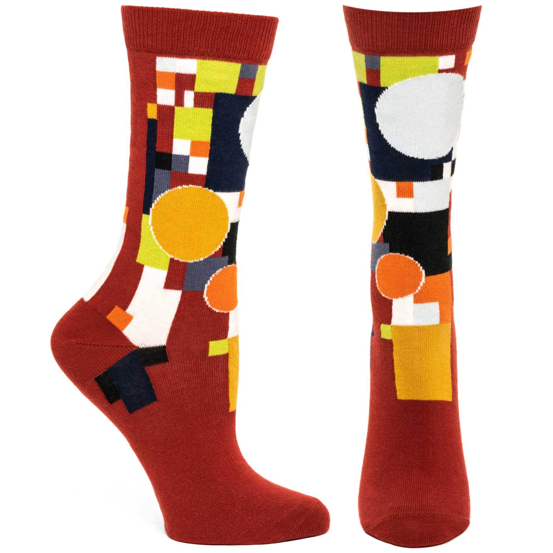 A pair of FLW Coonley Playhouse Socks featuring vibrant abstract stained glass designs inspired by Frank Lloyd Wright's architecture.