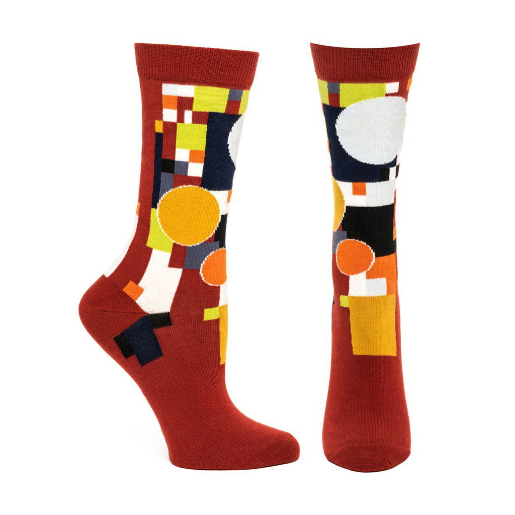 A pair of FLW Coonley Playhouse Socks featuring vibrant abstract stained glass designs inspired by Frank Lloyd Wright's architecture.